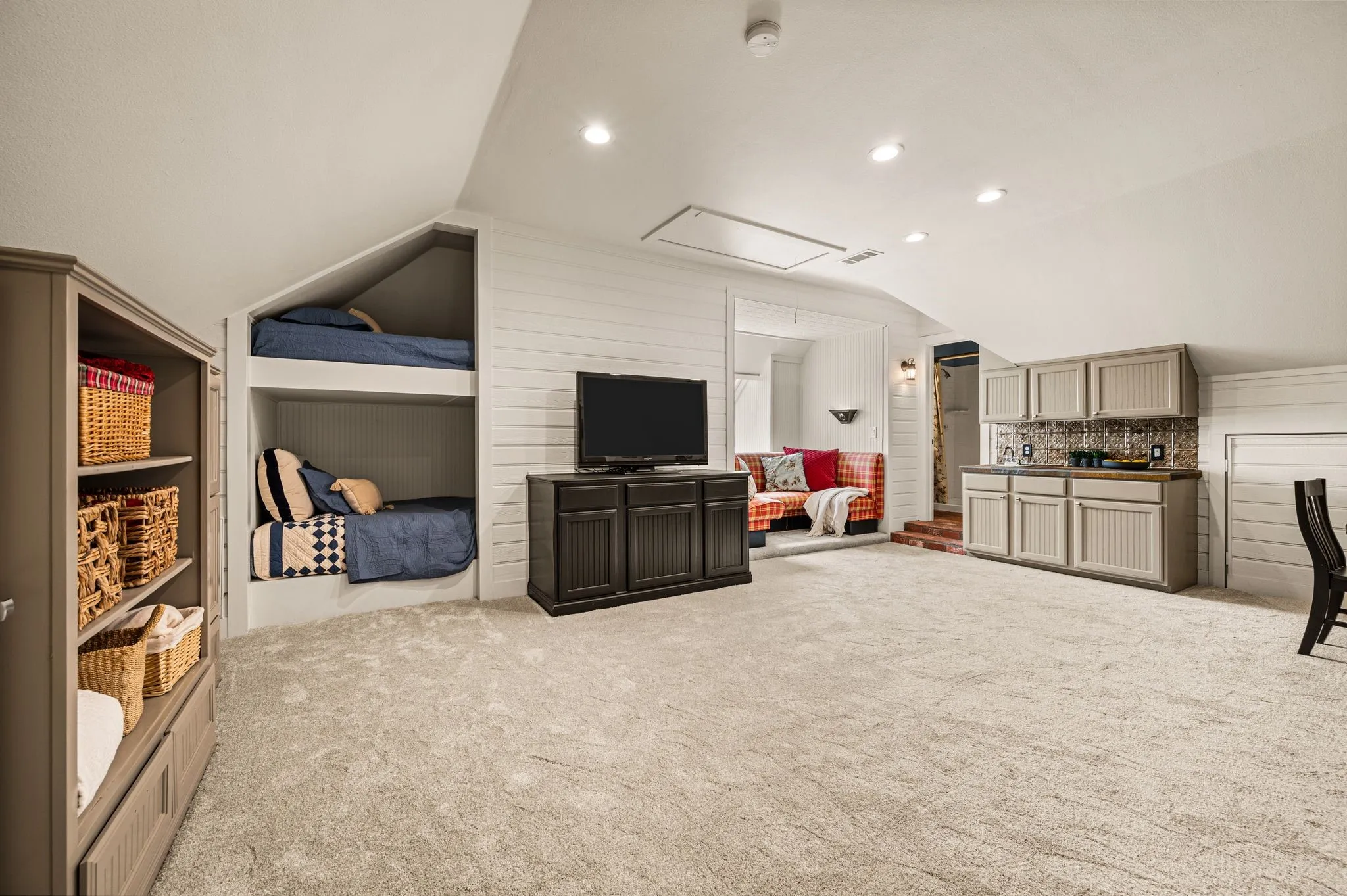 The third-floor game room is designed for real family life, with built-in bunks, generous open space and a kitchenette that keeps everything close at hand.