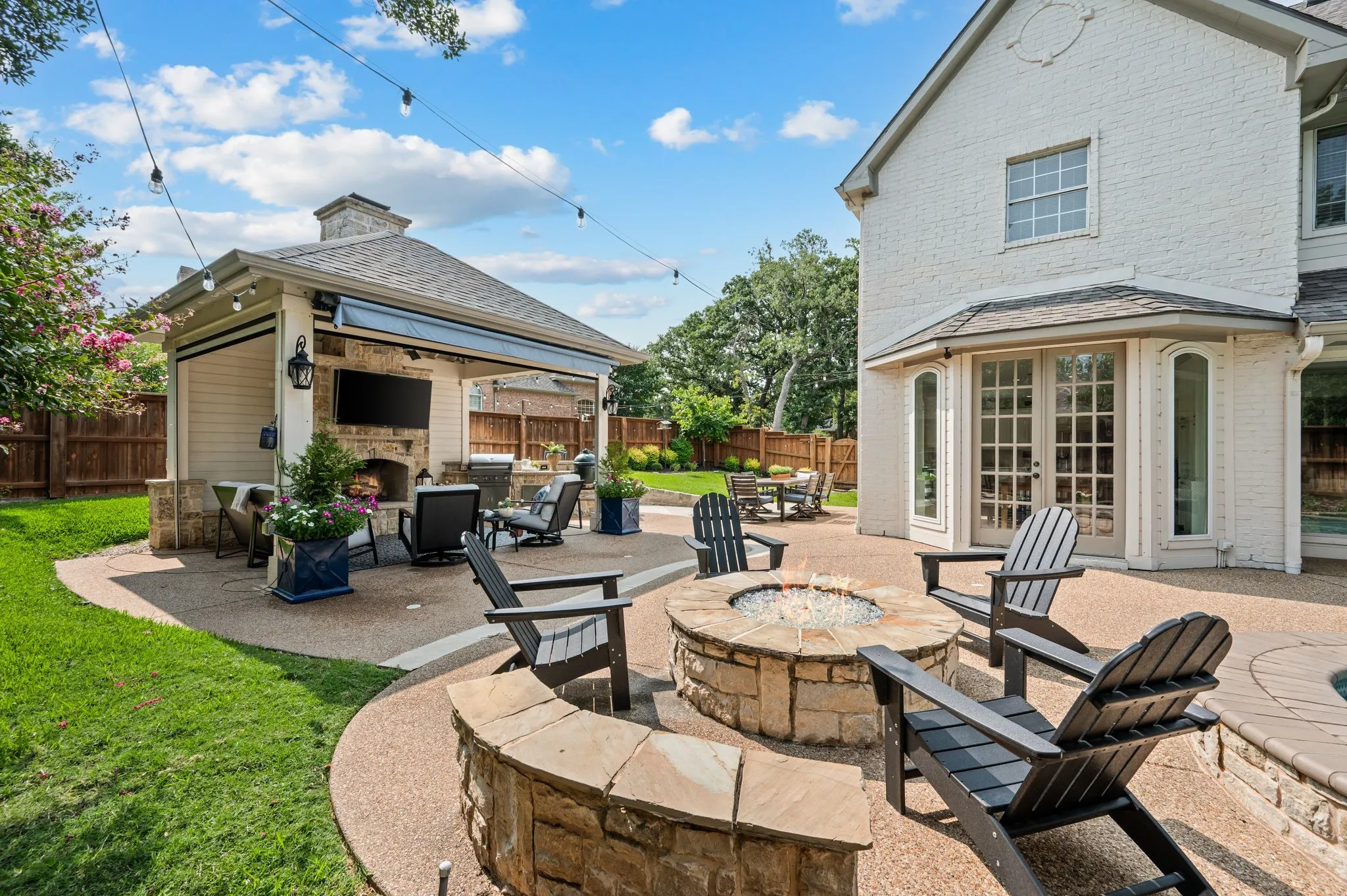 A stone fire pit anchors the backyard, creating the kind of place where everyone naturally gathers as the evening cools.