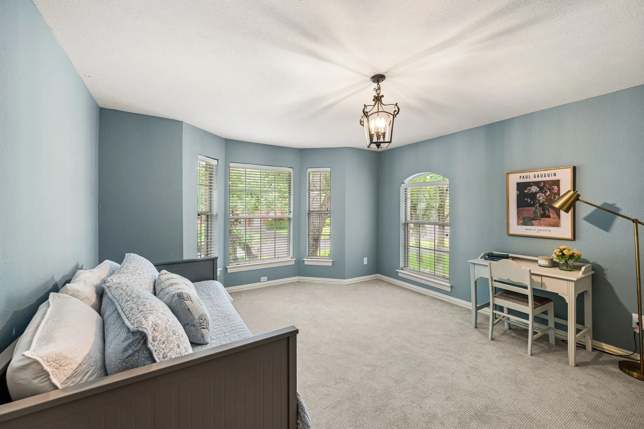 A secondary bedroom is filled with natural light and offers plenty of room for a bed, desk and sitting area.