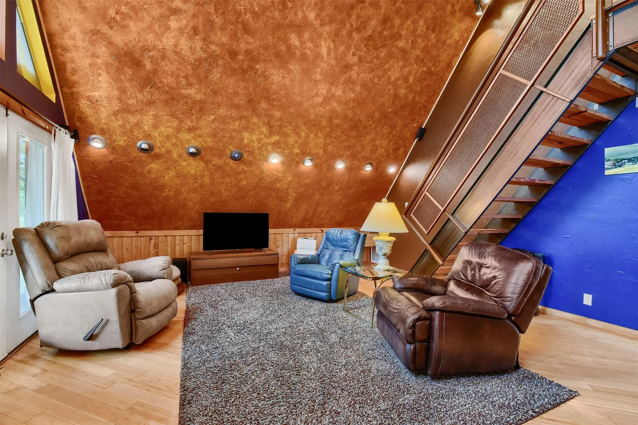 Living room featuring a towering ceiling and hardwood / wood-style floors