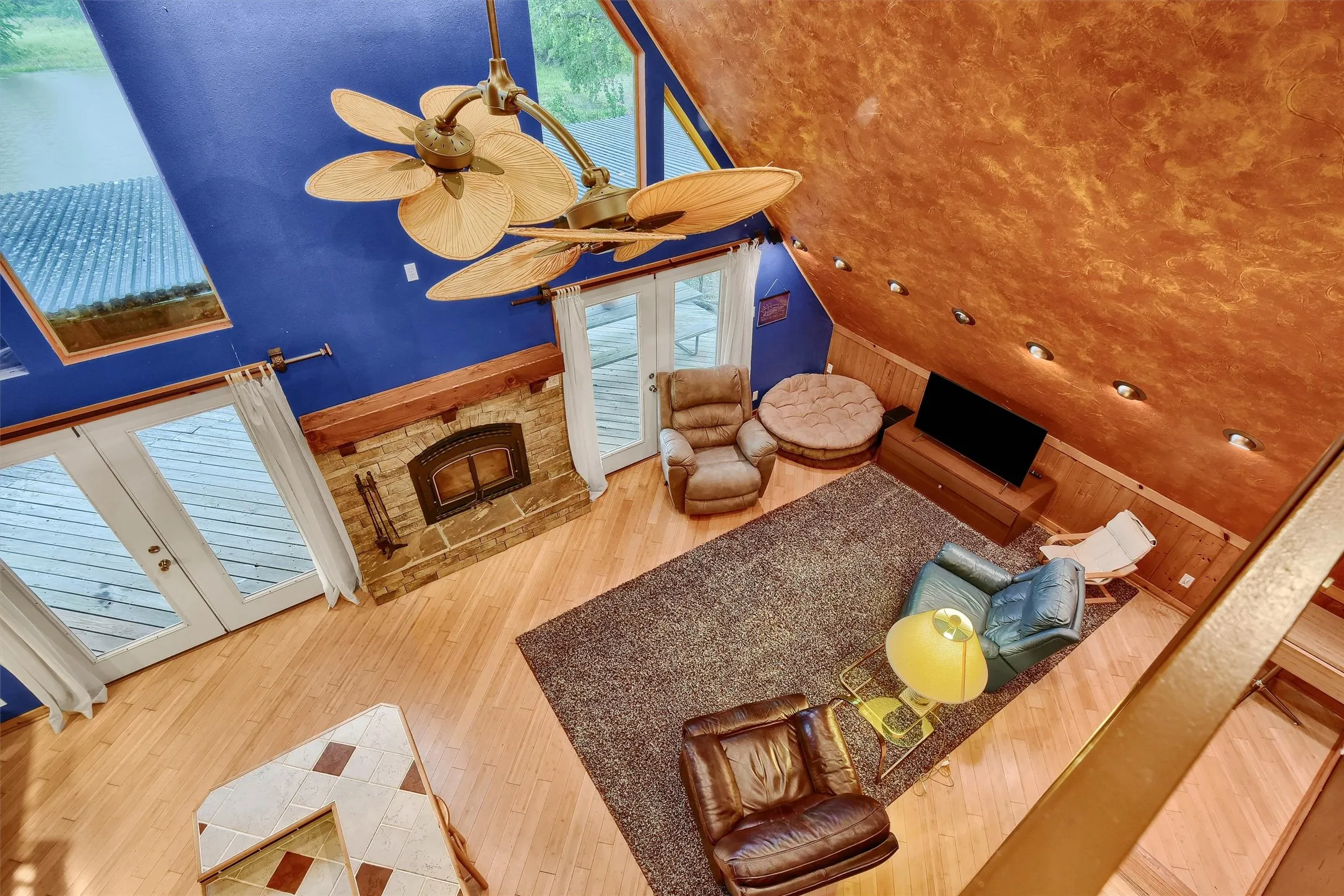 Living room featuring a stone fireplace, sink, french doors, and hardwood / wood-style flooring