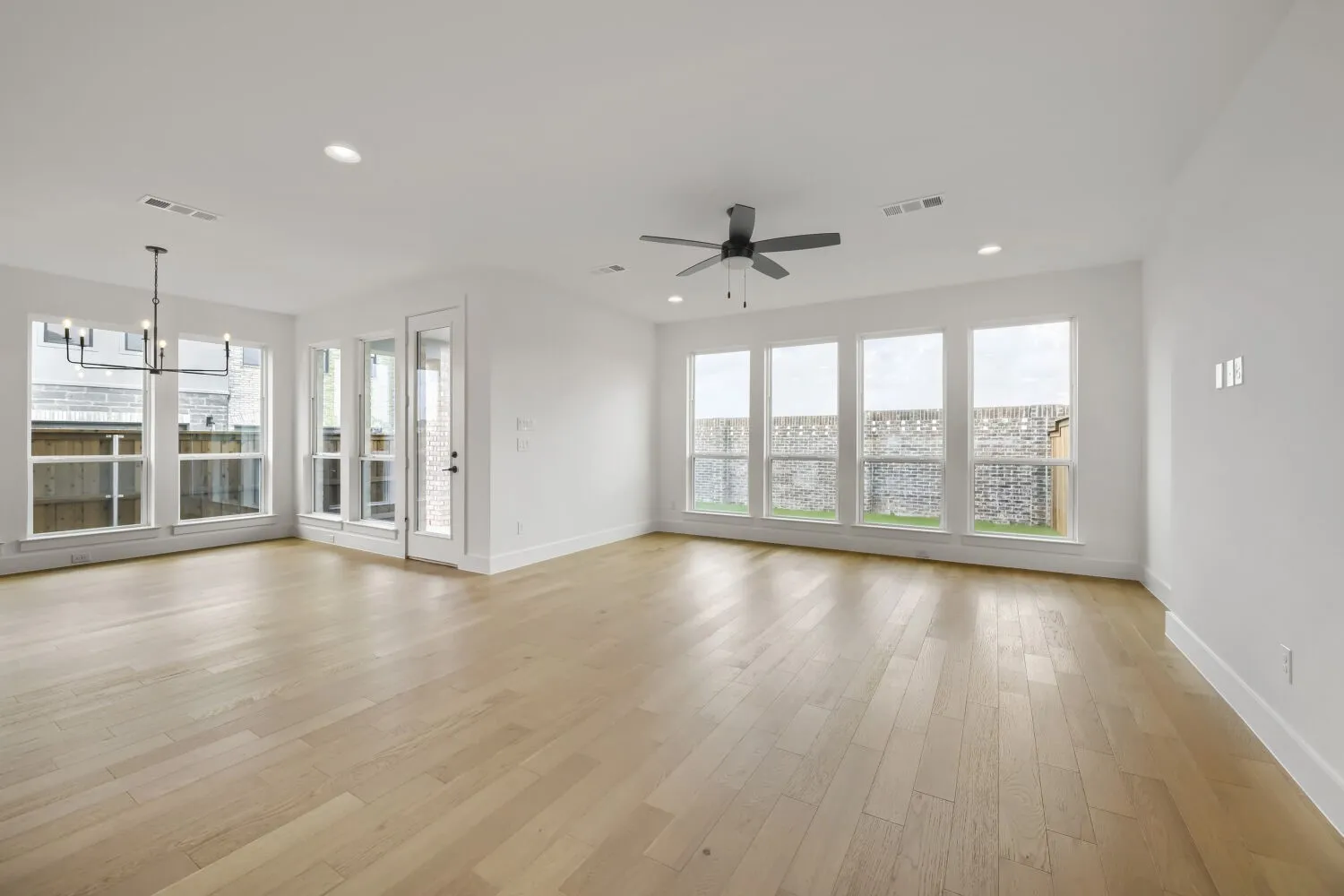 Light wood-finish flooring, white walls, recessed lighting, and a ceiling fan