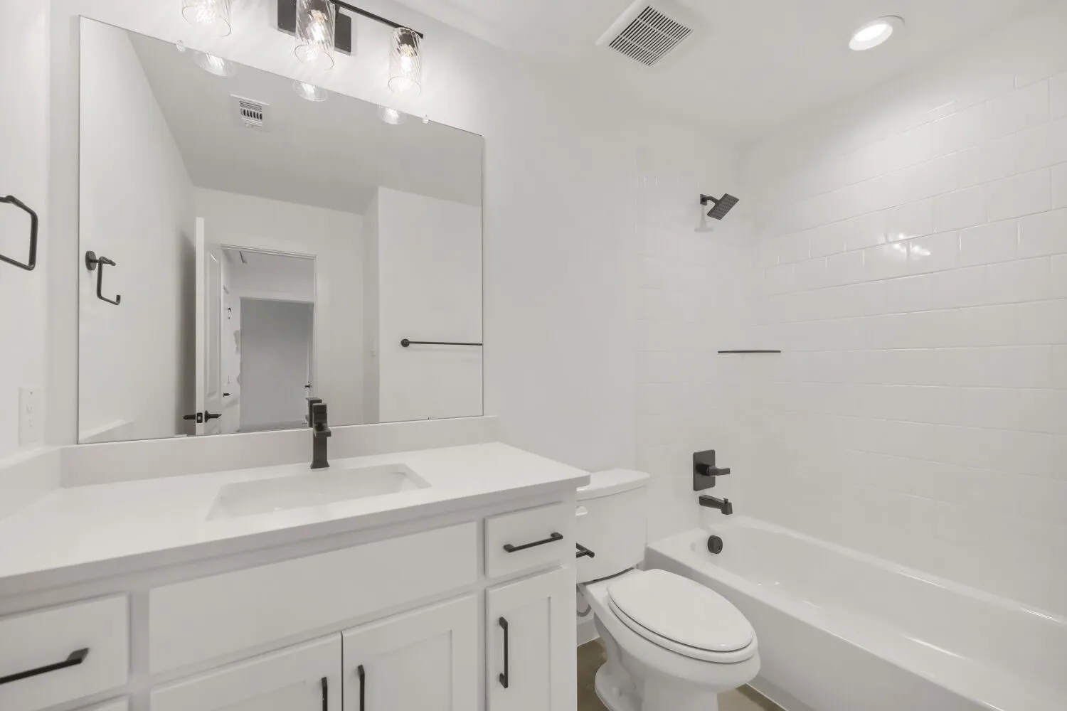 White vanity with integrated sink and matte black faucet