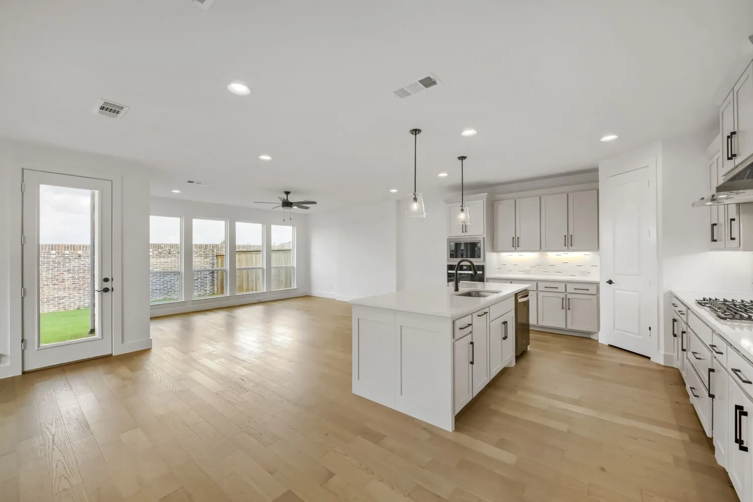 Open concept kitchen with a central island, recessed lighting, and wood-finish flooring