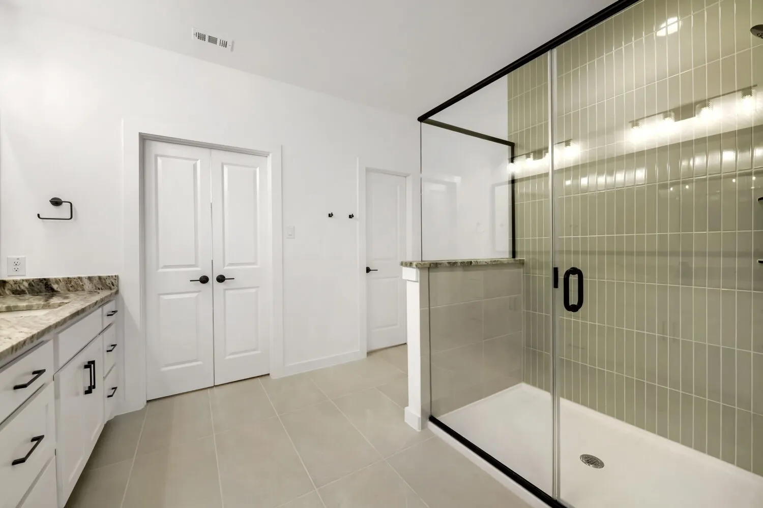 Custom tile shower with glass enclosure and black hardware