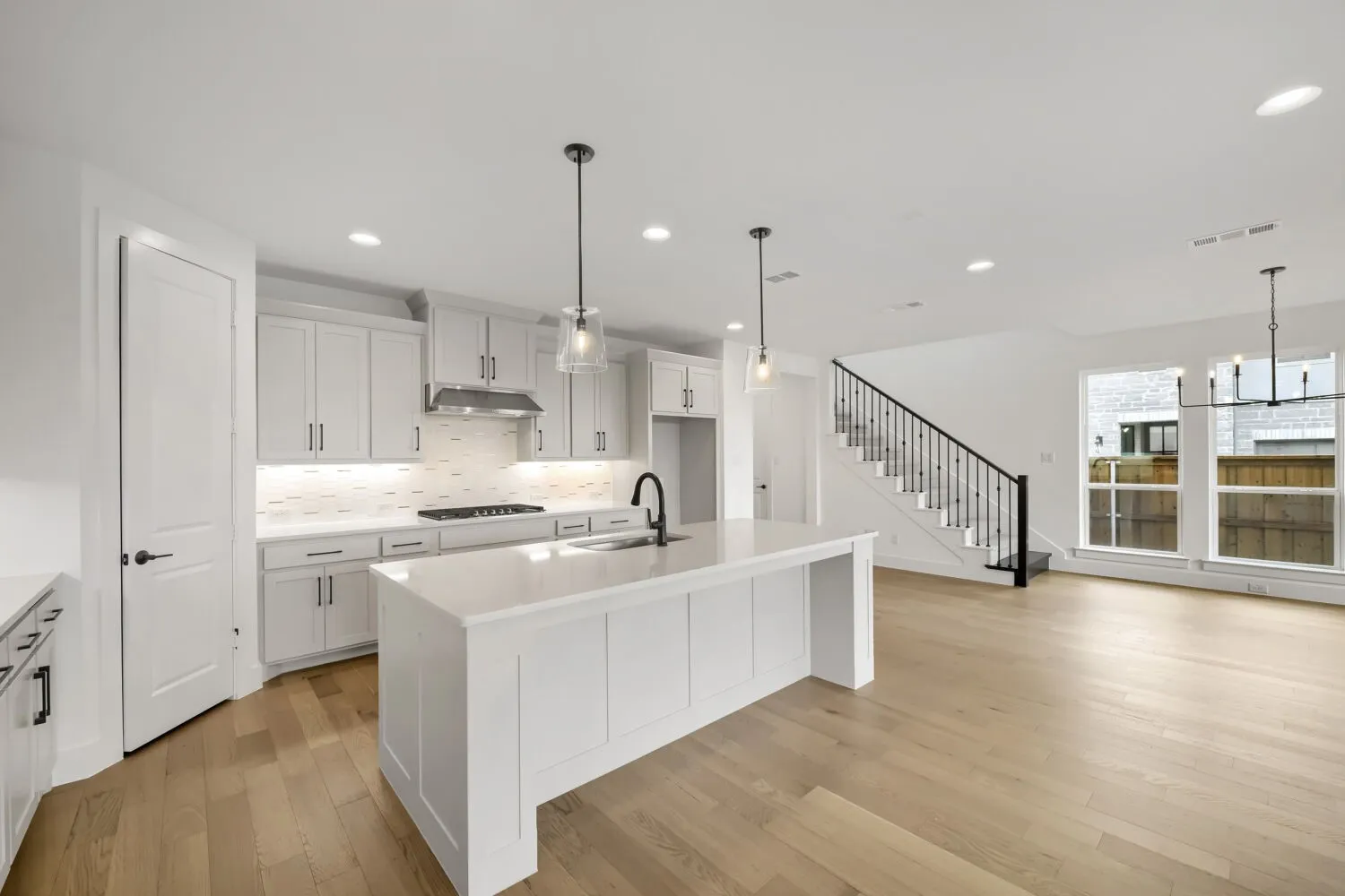 Gourmet kitchen with white cabinetry and an oversized island