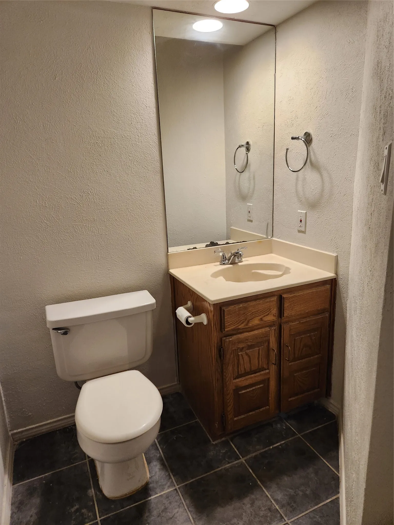 Wood-finish flooring with light wood grain, white painted walls, and white trim molding