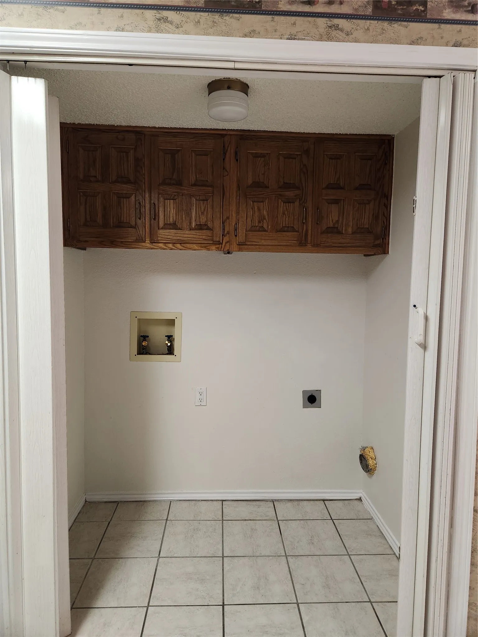 Built-in storage cabinetry, tile flooring, and utility hookups
