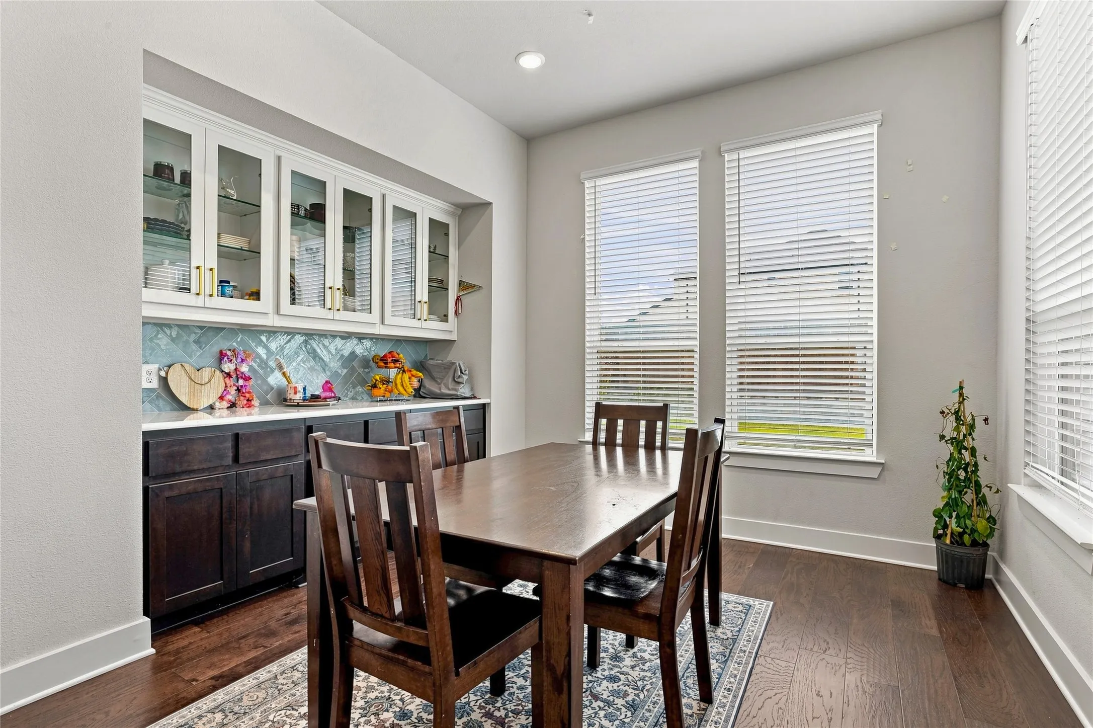 Built-in cabinetry with glass-front uppers and dark wood-finish base cabinets