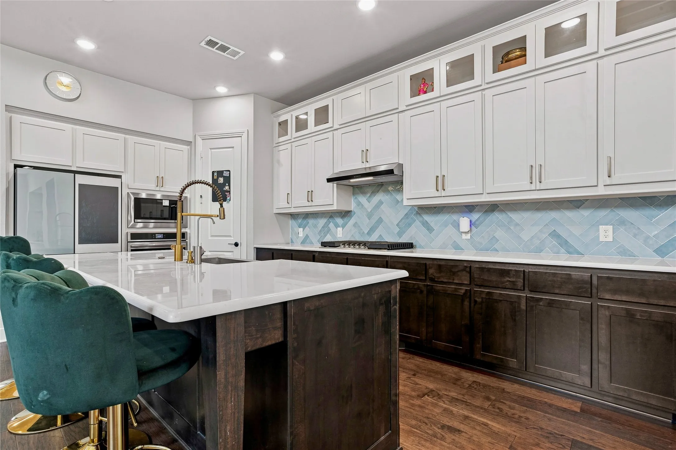Expansive kitchen island with a white countertop and gold-finish faucet