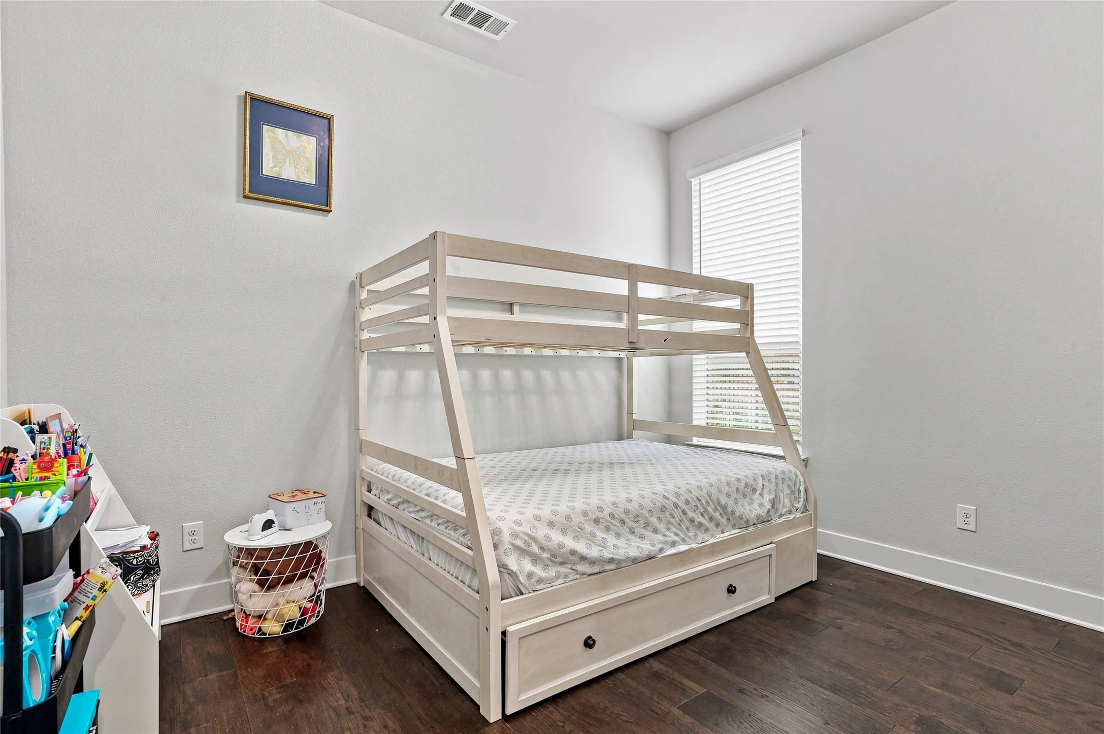 Hardwood-style flooring and a window with blinds