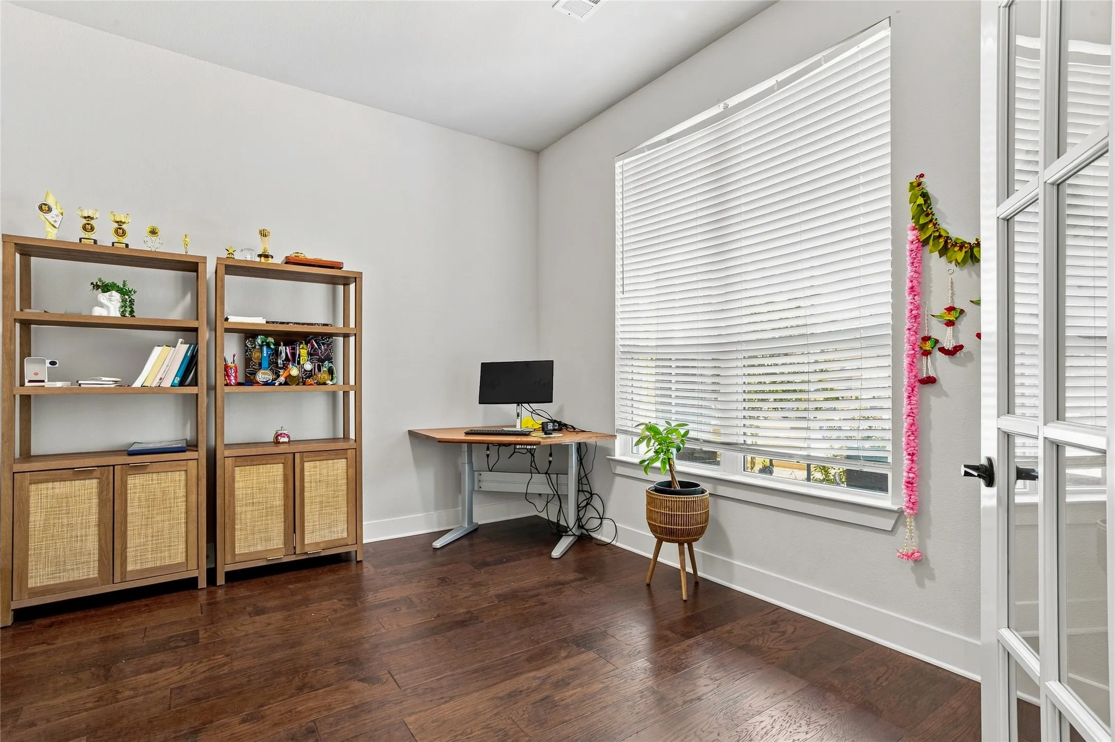 Hardwood flooring and white wall paint create a bright interior