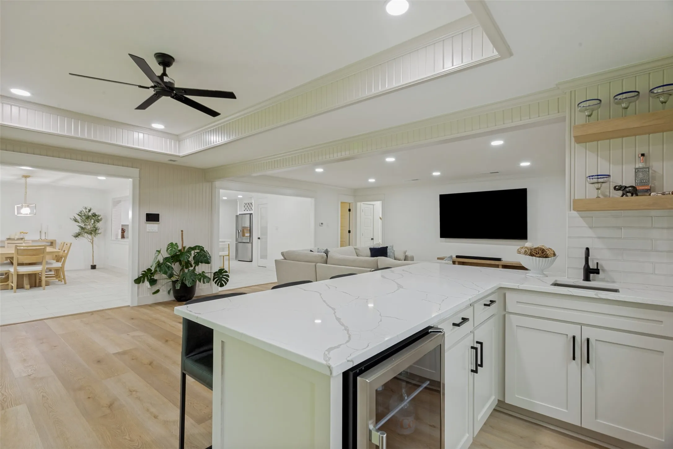 Light wood-finish flooring with recessed lighting and a built-in beverage refrigerator
