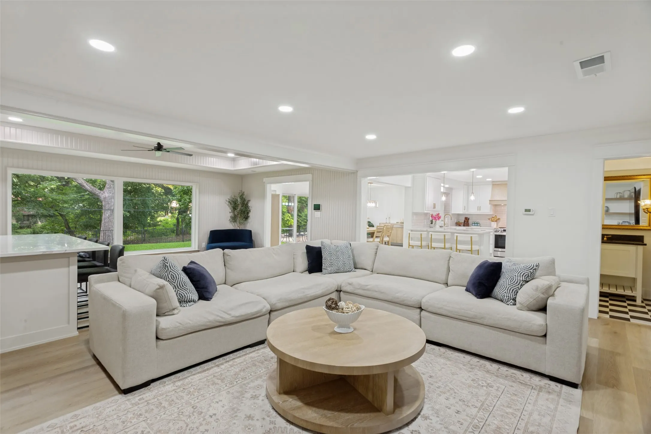 Recessed ceiling lighting, wood-finish flooring, expansive windows, open-concept design, and a ceiling fan