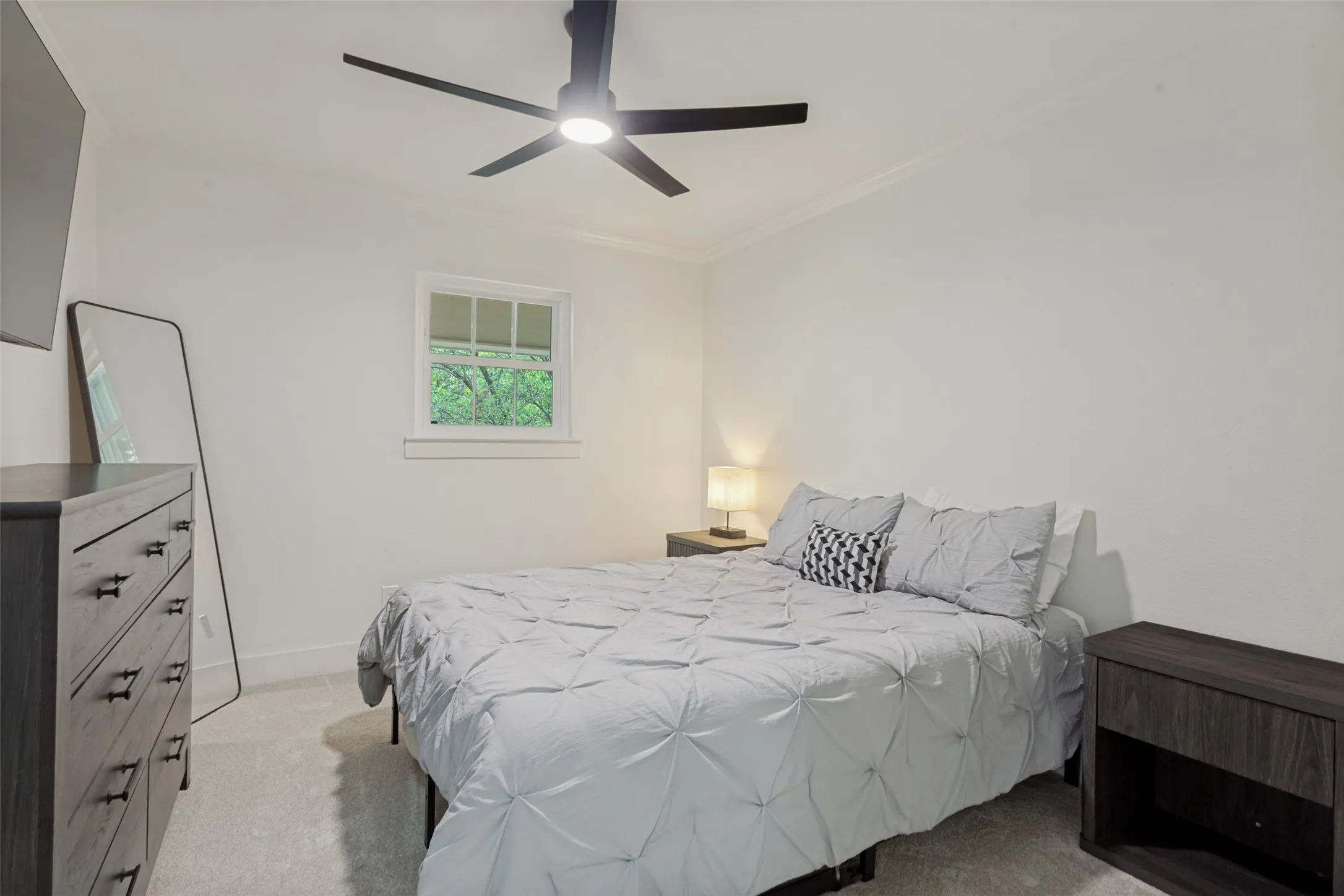 Recessed window with white trim, crown molding, and a modern ceiling fan with integrated lighting