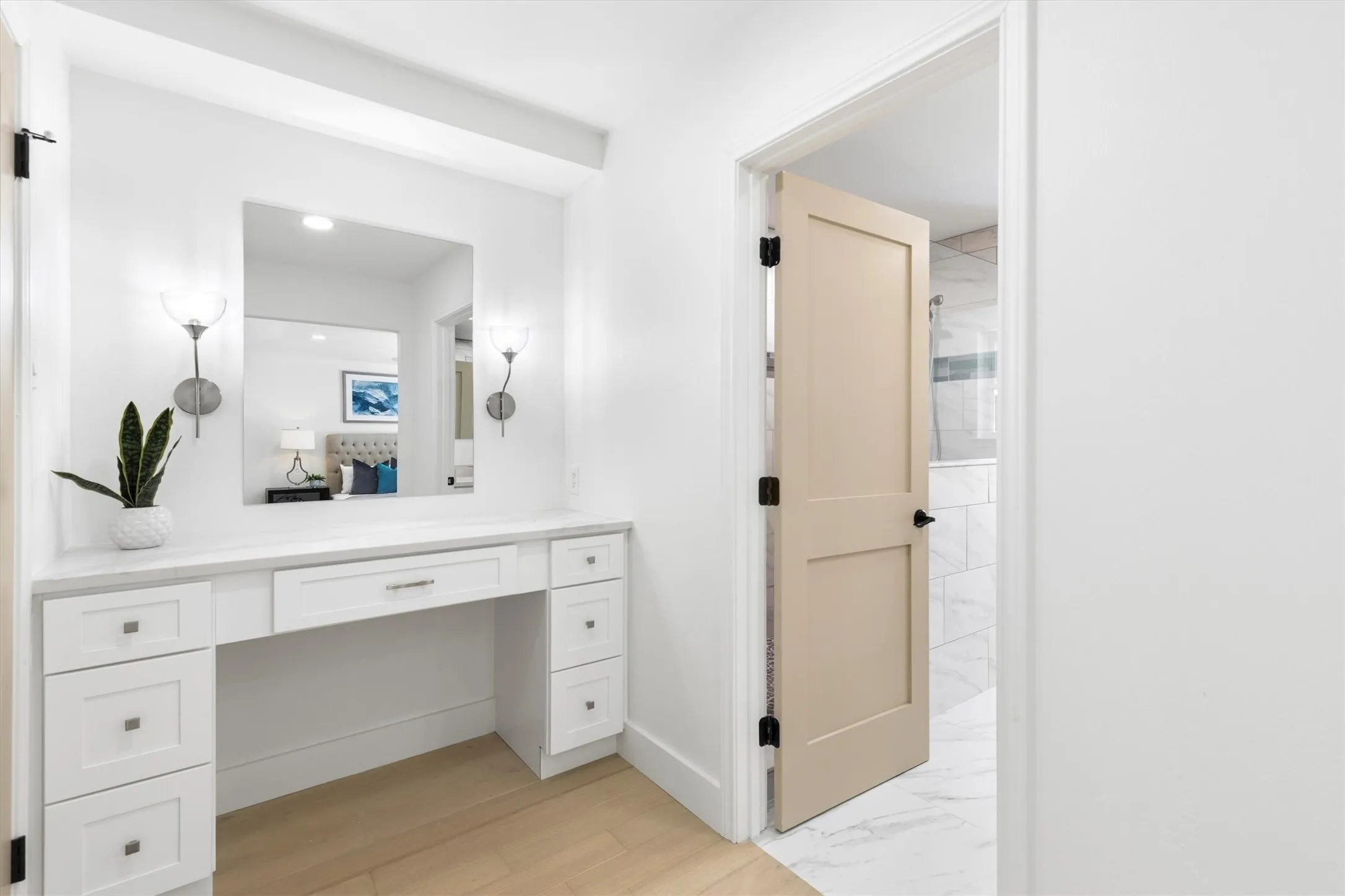 Built-in vanity with a stone countertop, square mirror, and two wall sconces