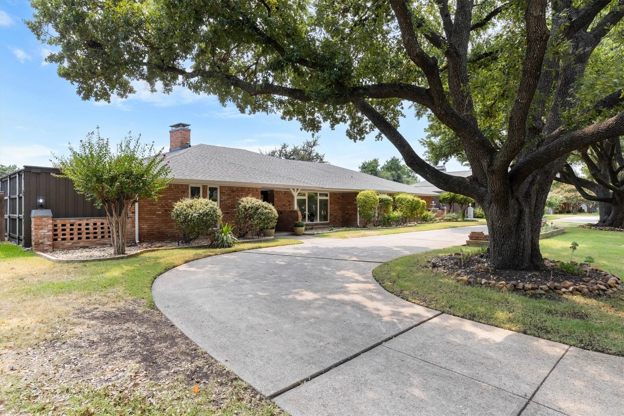 Brick exterior with circular drive and mature trees