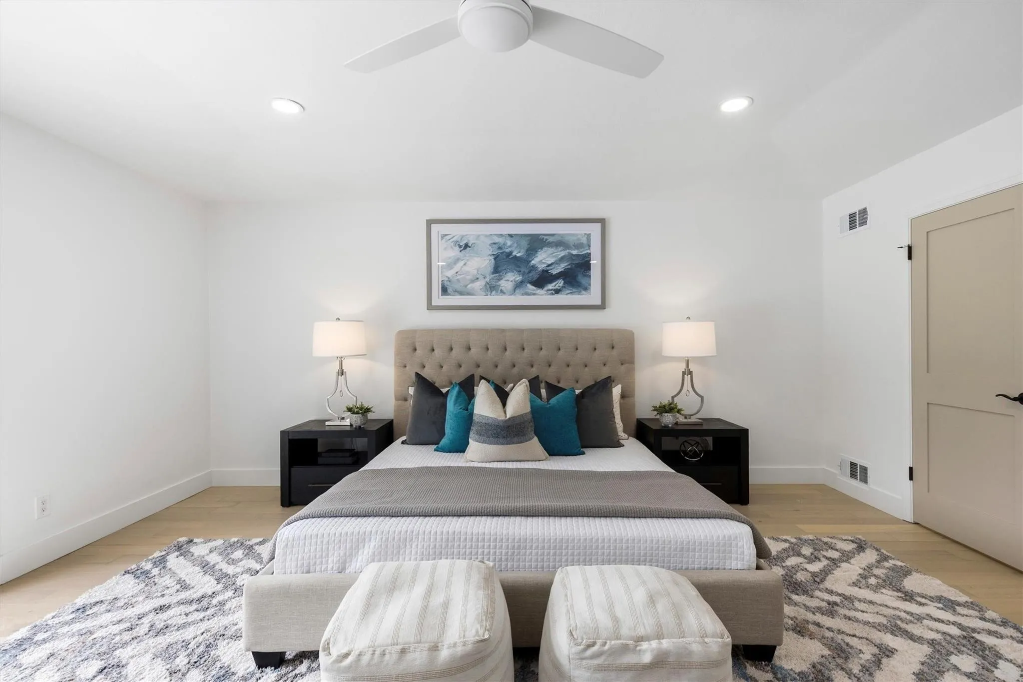 Recessed ceiling lighting, wood-finish flooring, ceiling fan, and a light-colored interior door with dark hardware