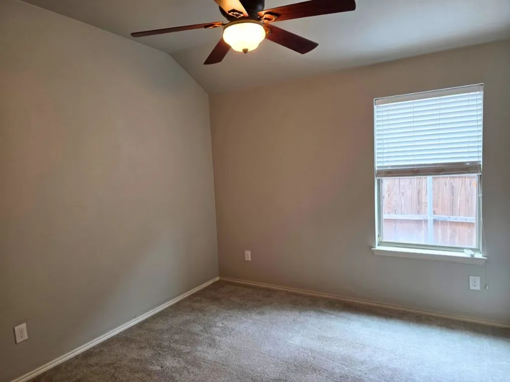 Vaulted ceiling featuring a ceiling fan with light fixture