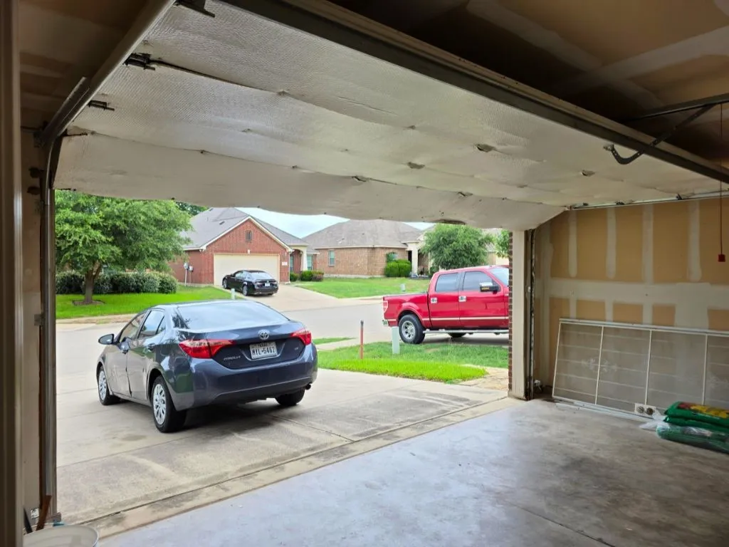 Spacious garage with a concrete floor and a partially visible insulated garage door