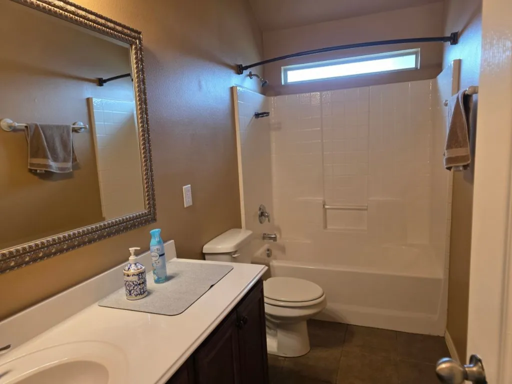 Bathroom with a white vanity featuring an integrated sink and dark wood-finish cabinetry