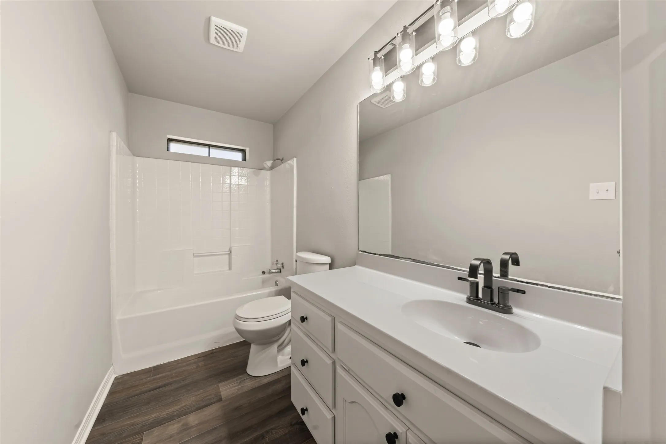 White vanity with a solid surface countertop and undermount sink