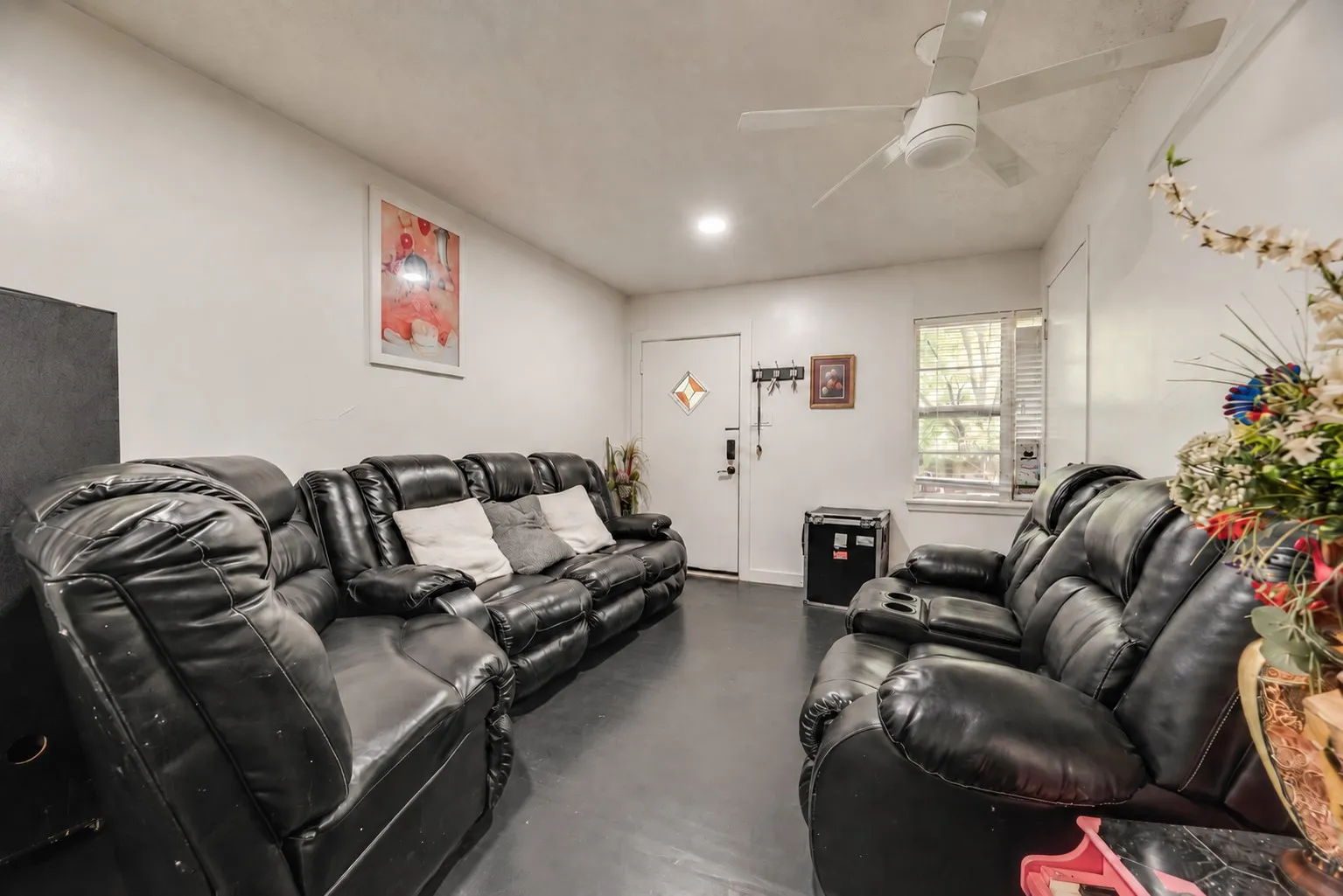 Recessed lighting and a ceiling fan fixture illuminate the interior space