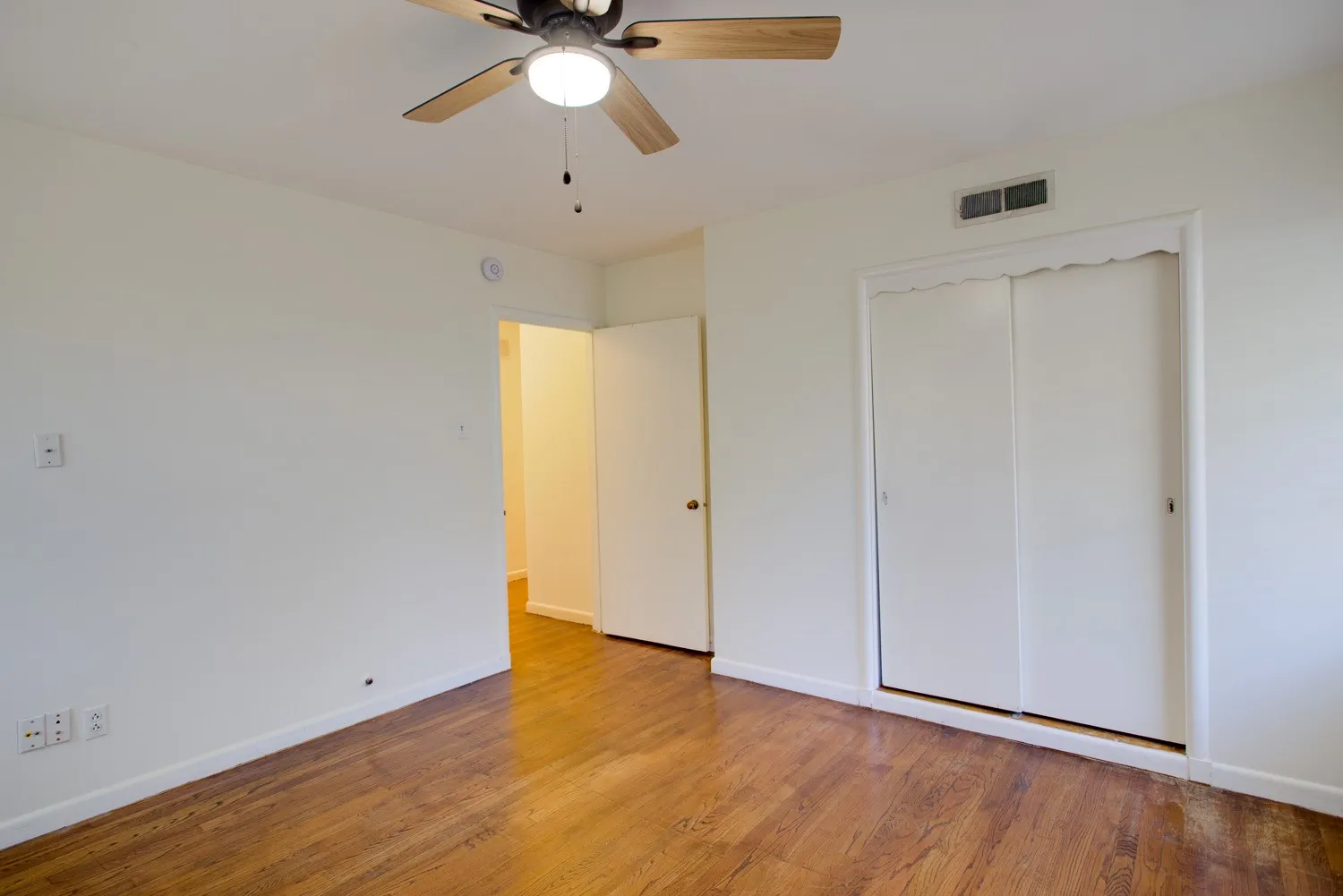 Back Bedroom with hardwood floors and bi-fold closet doors