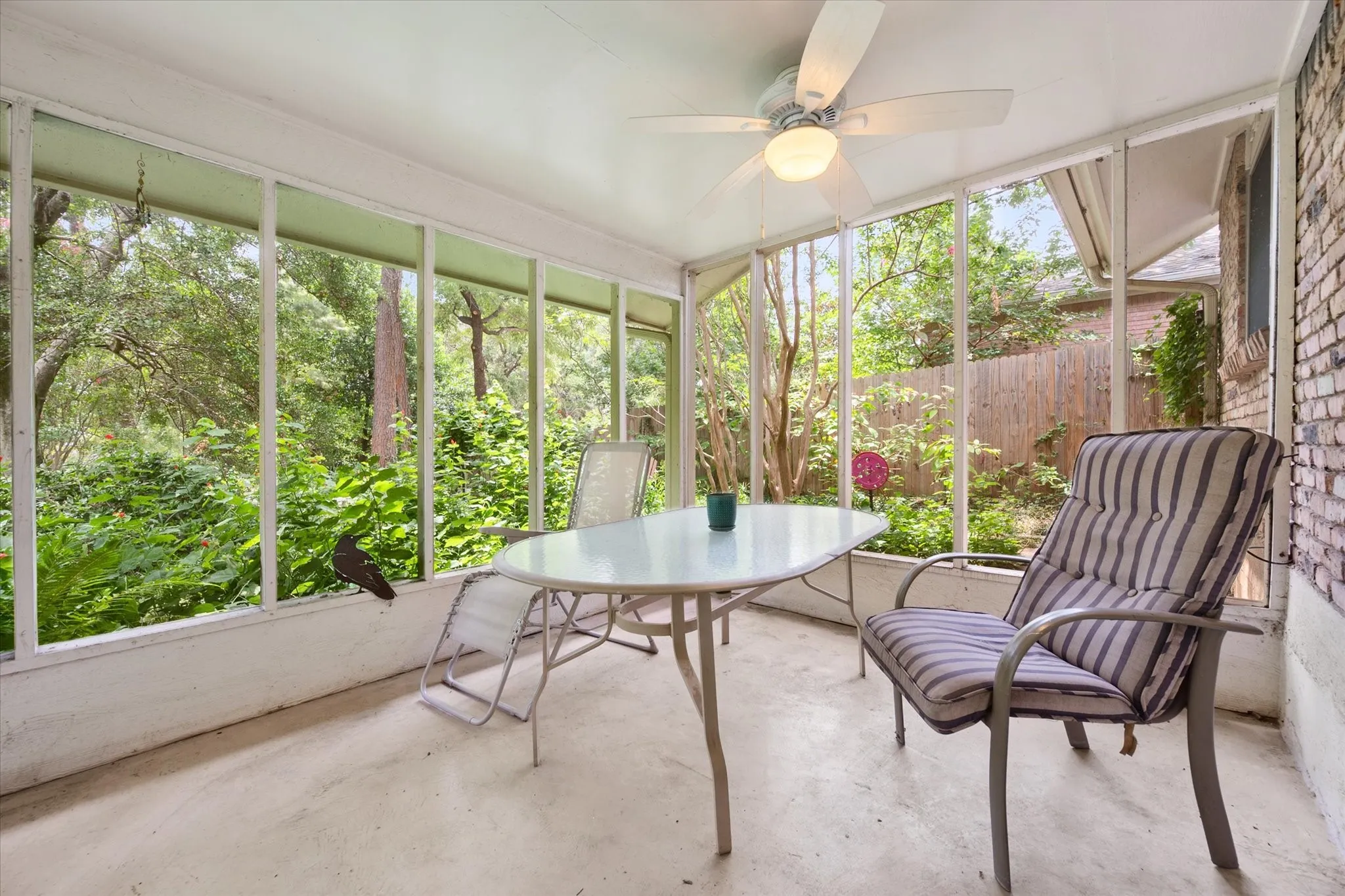 Screened porch with ceiling fan, providing an outdoor living space