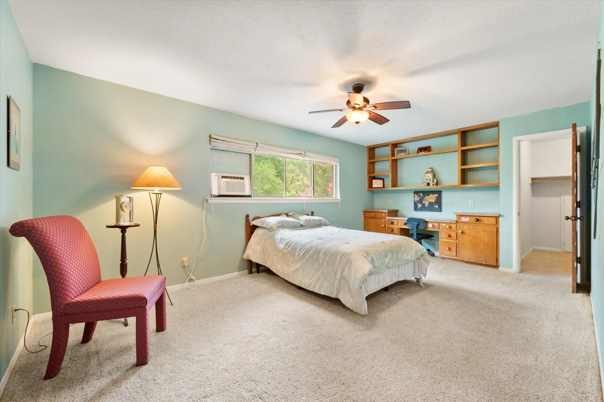 Bedroom 2 feautures built-in wooden shelving & integrated desk, private access to a full bathroom and a large walk-in closet.
