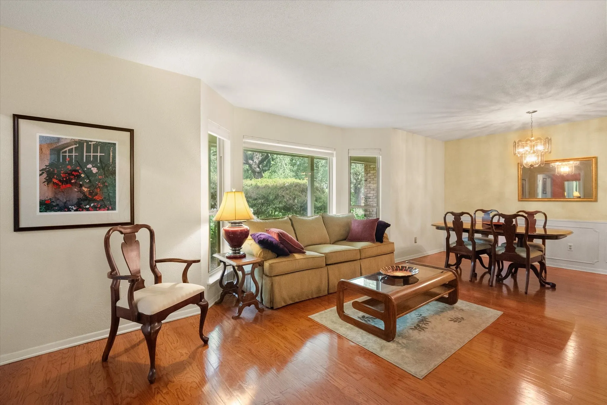 Hardwood flooring, bay window, chandelier lighting, and a chair rail accent the formal living & dining areas.