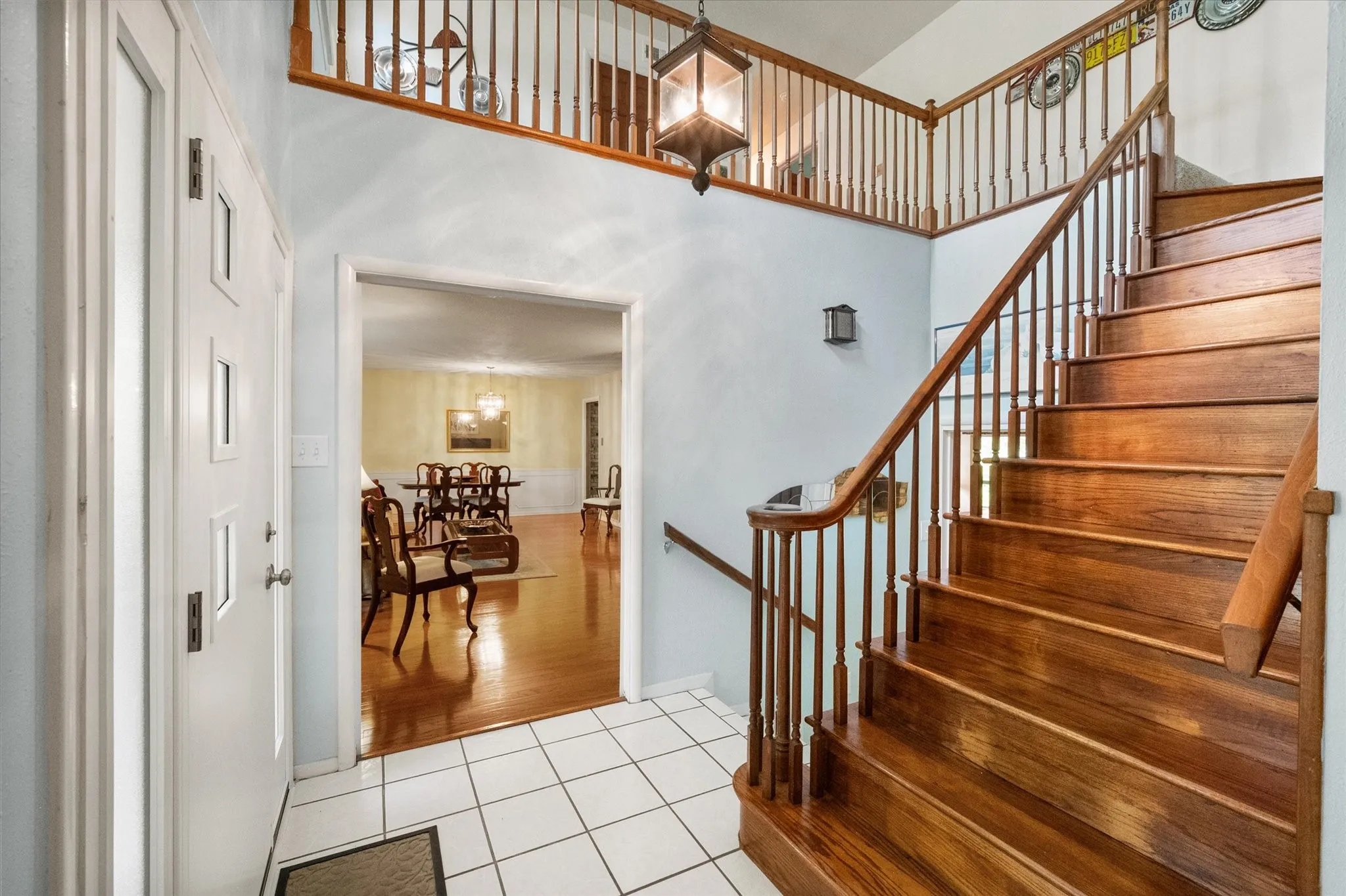 Two-story entryway featuring wood stairs and balusters, and opens up to the formal areas and the secluded den.