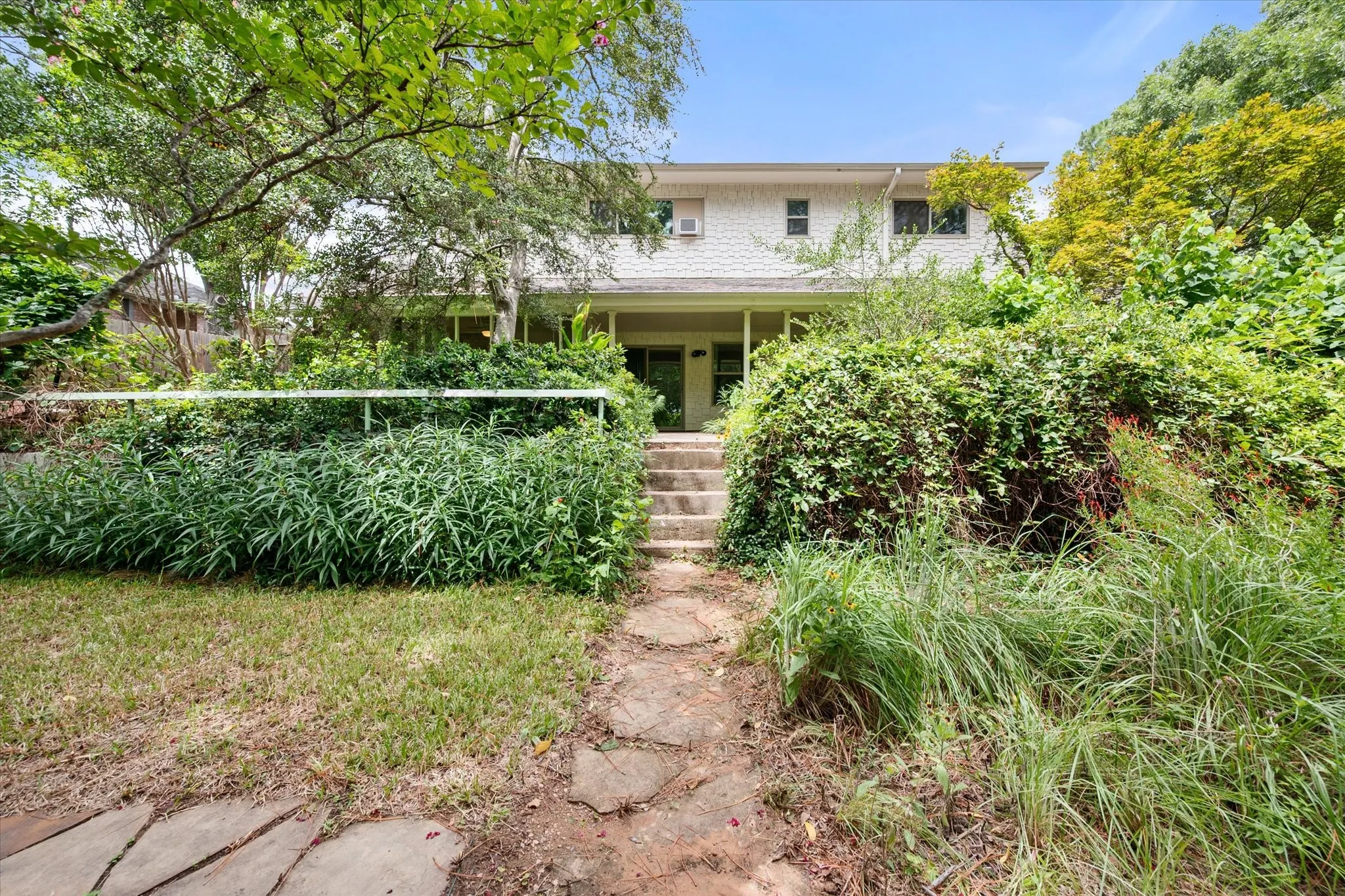 Stone walkways and lush landscaping in the backyard.