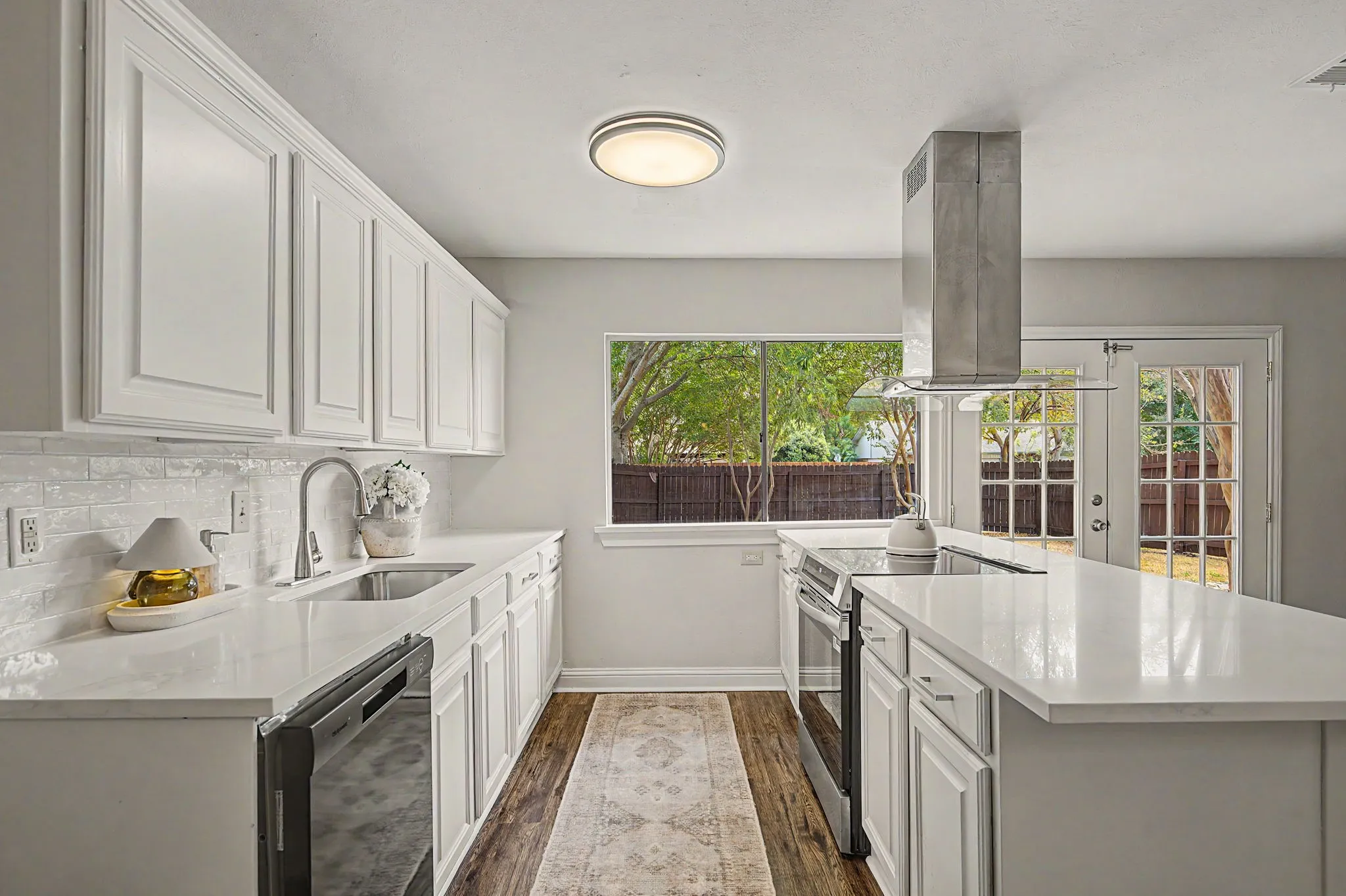 Stunning recently remodeled kitchen with 3cm Quartz counter-tops, undermount sink and faucet, slide in electric range, and subway tile backsplash.