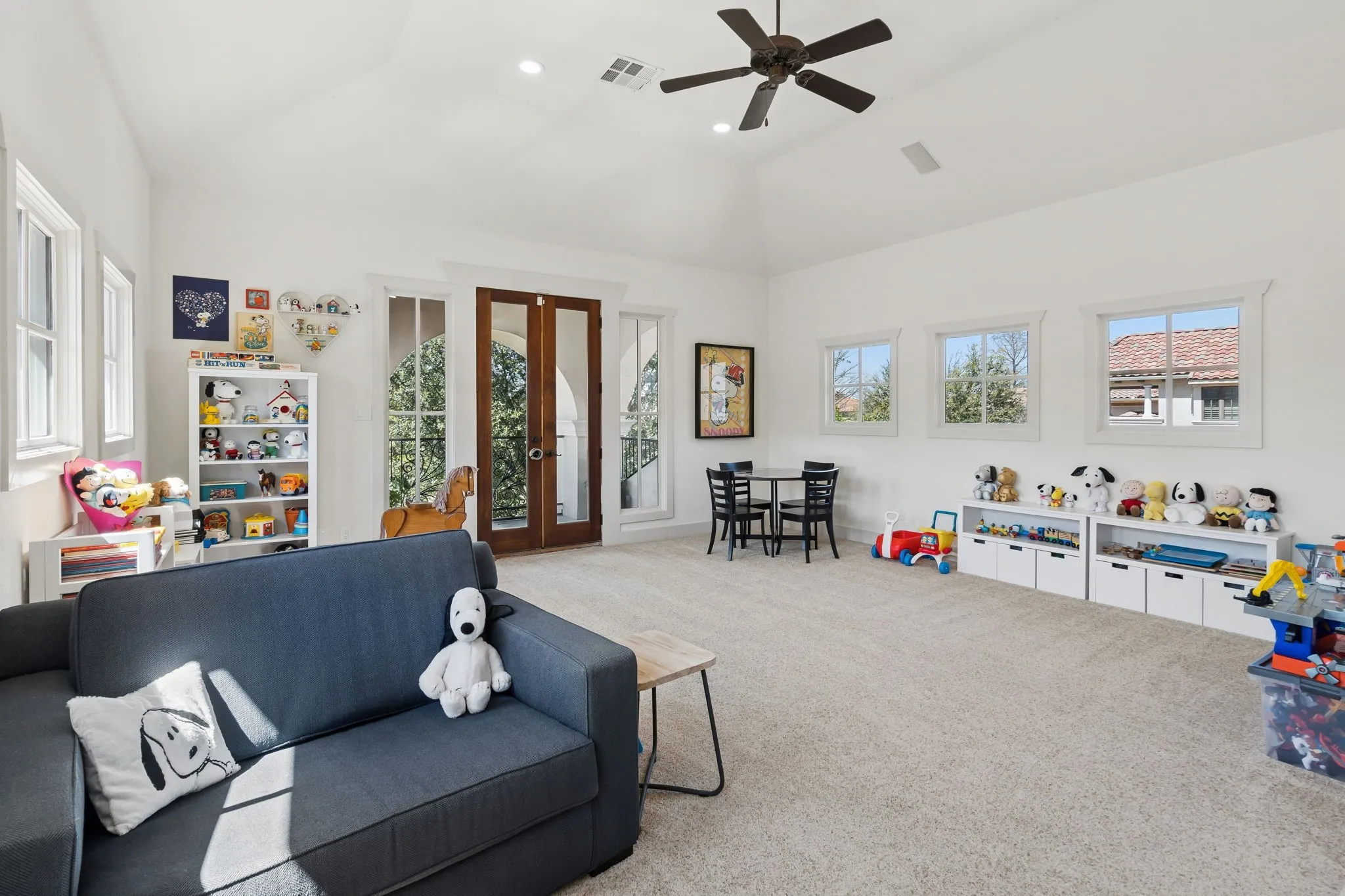 Spacious room featuring vaulted ceilings, recessed lighting, and multiple windows