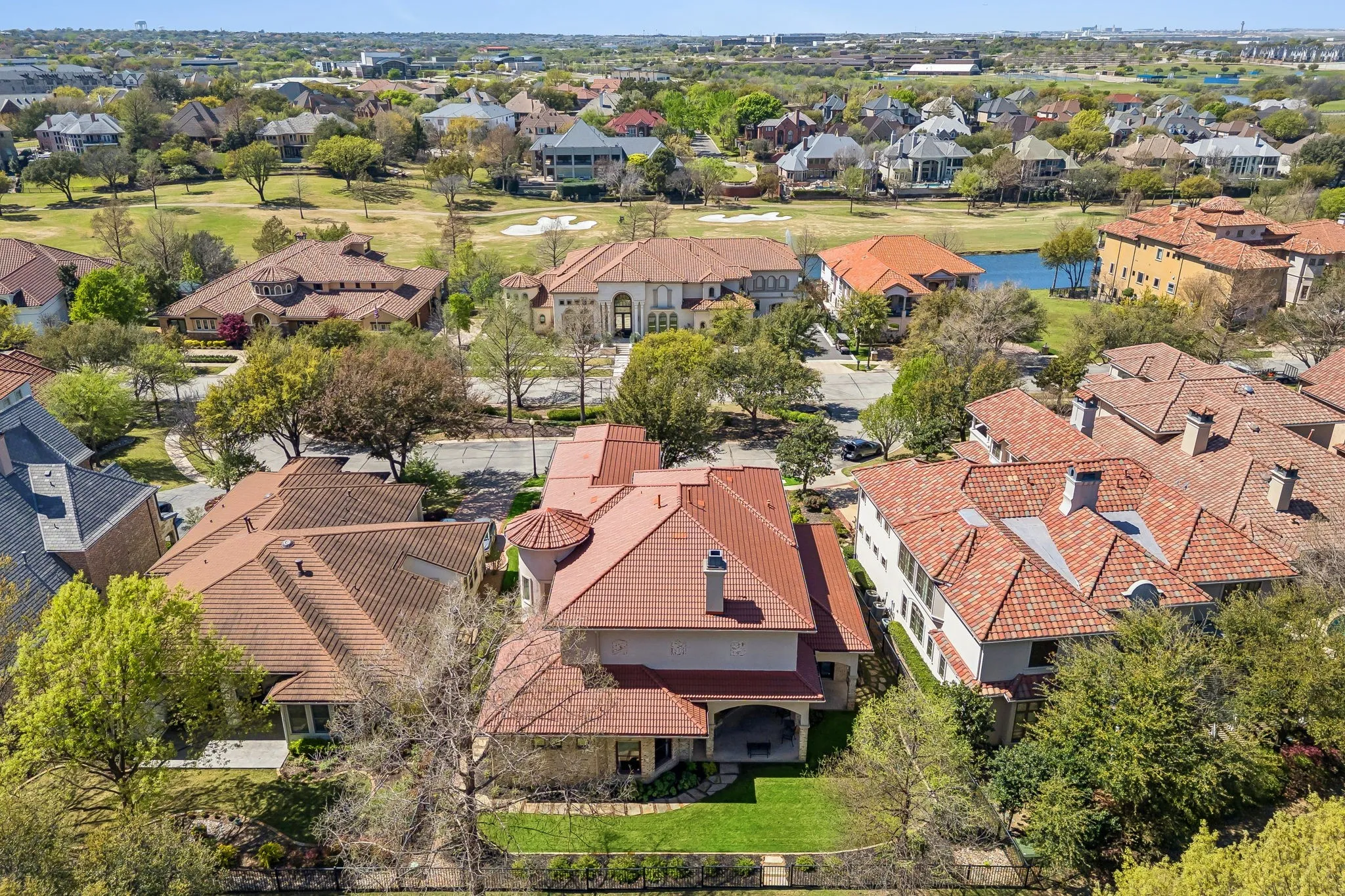 Terracotta tile roofs, stucco exterior, and established trees characterize this property