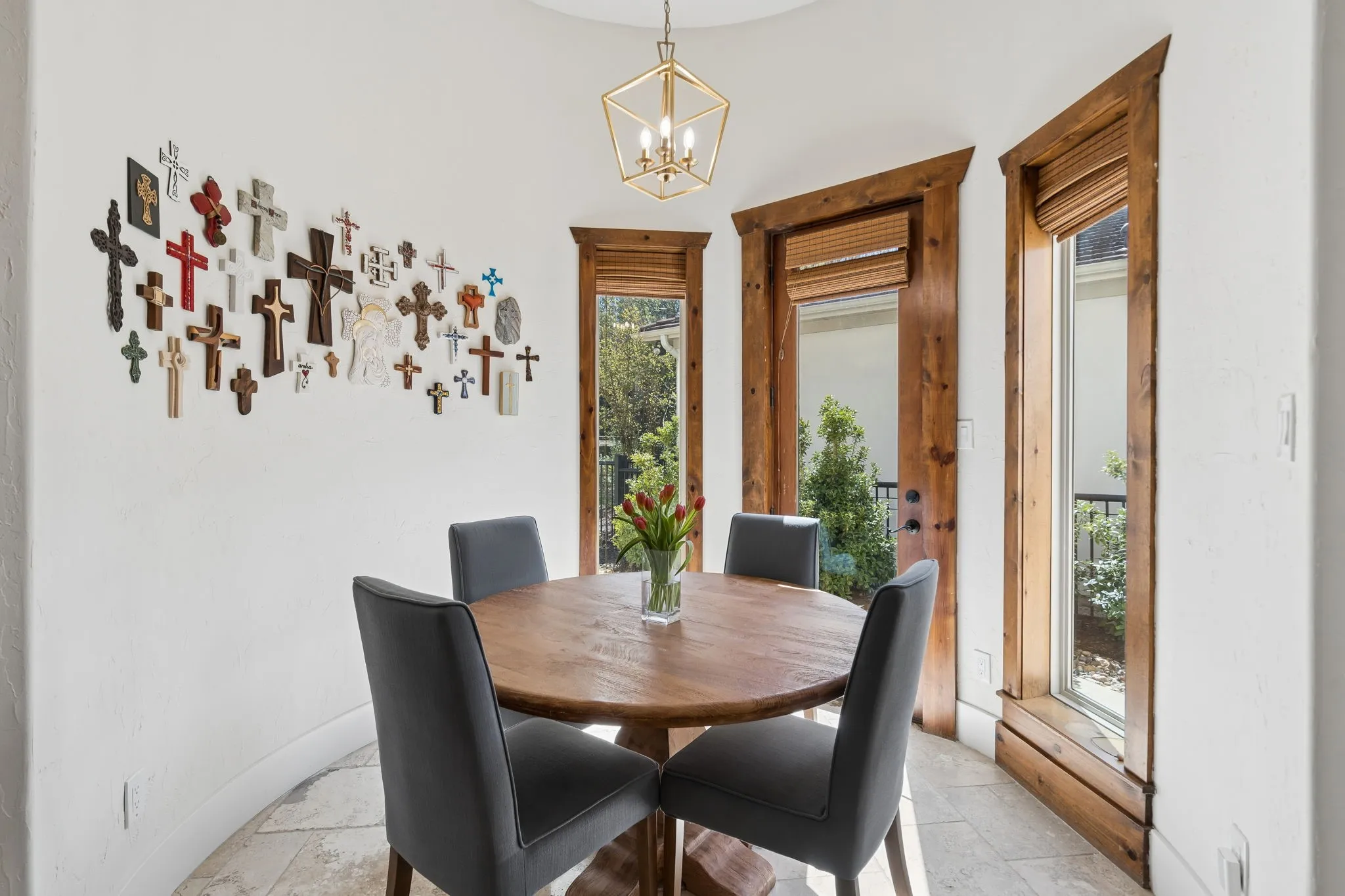 Tiled flooring with a circular dining area, featuring multiple windows with wood trim and integrated blinds, and an overhead geometric light fixture