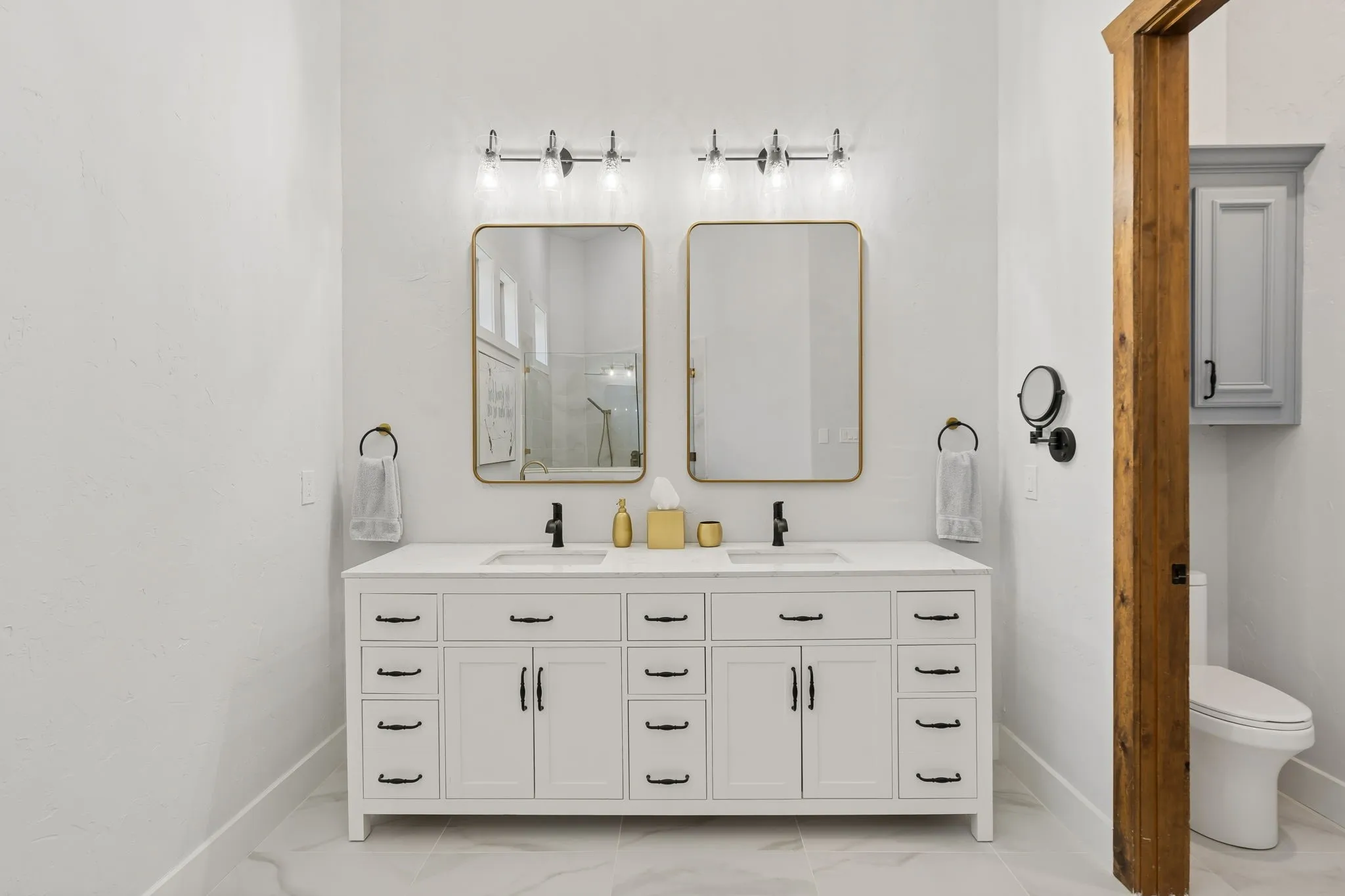 Dual vanity with a white countertop and integrated sinks, matte black hardware, and two framed mirrors