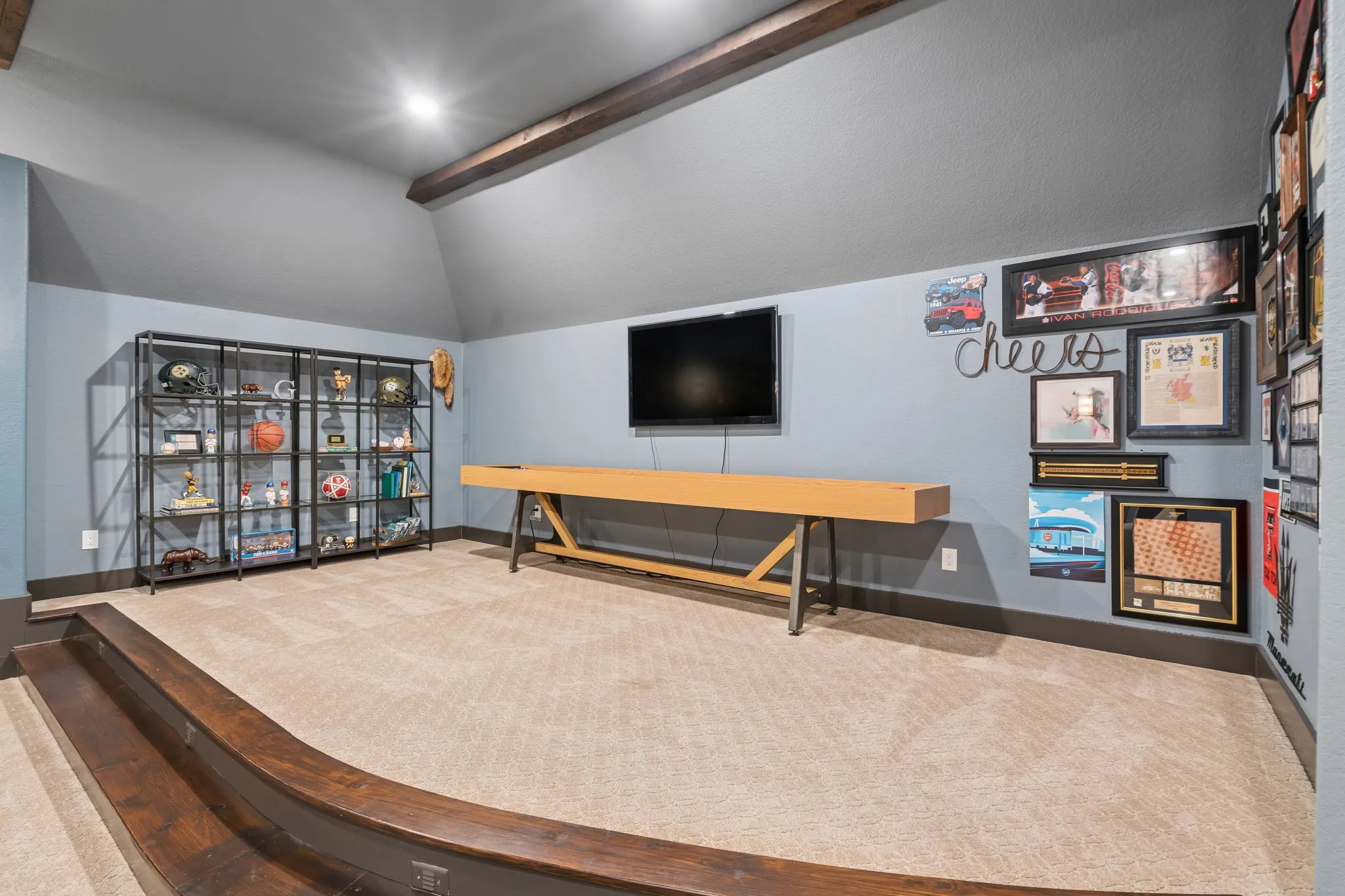 Carpeted flooring, vaulted ceiling with exposed wood-finish beams, recessed lighting, and built-in shelving