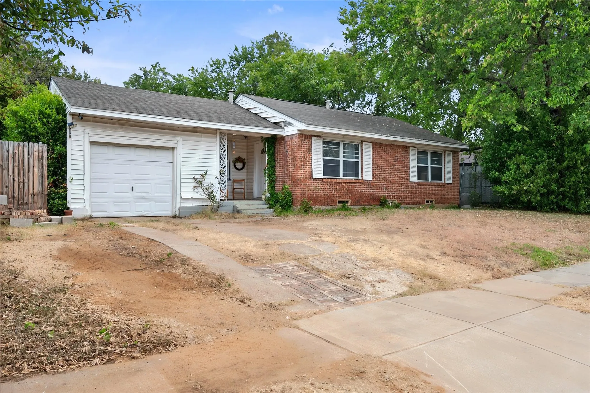Brick and siding exterior featuring a covered entry, attached garage, and multi-pane windows