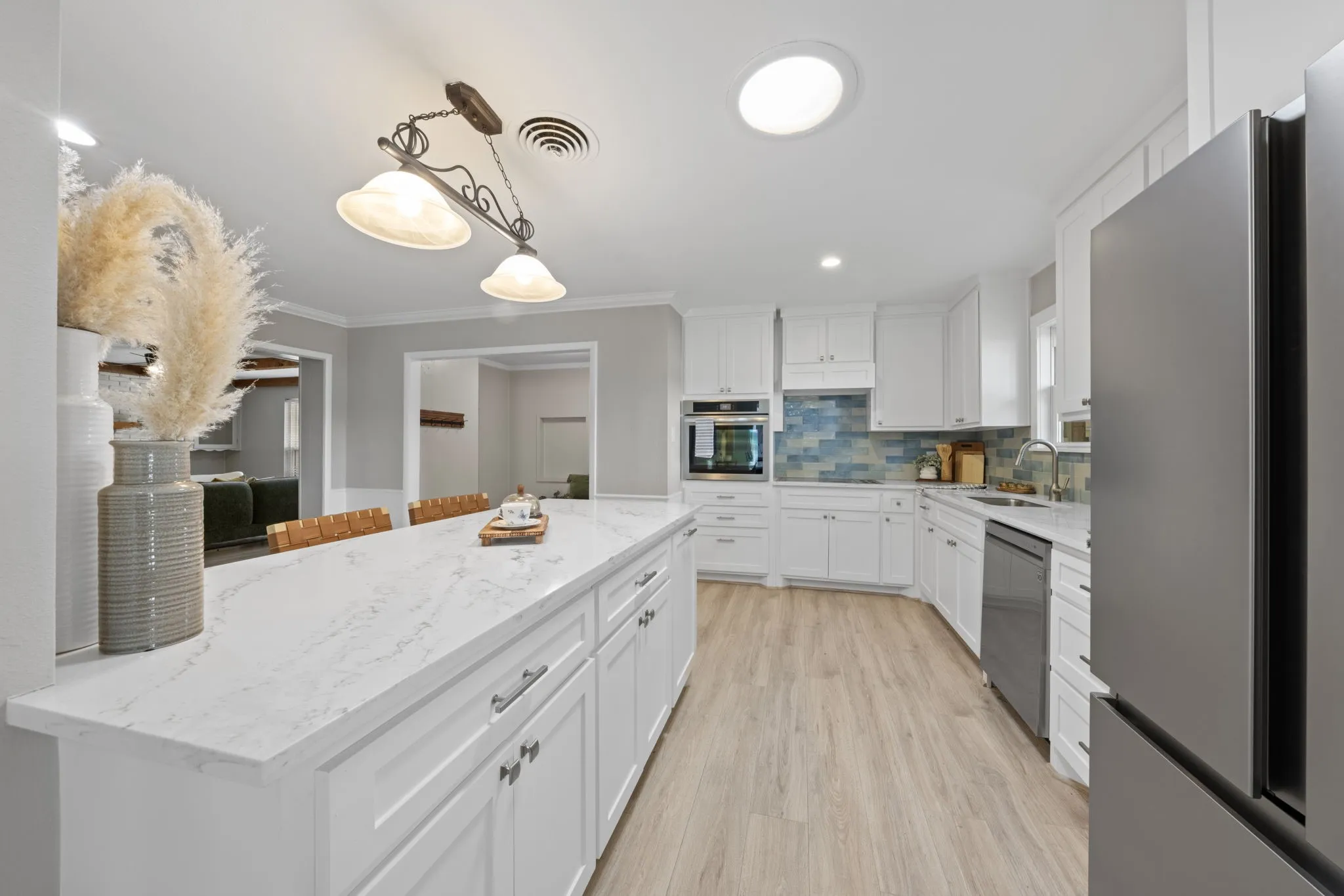 Kitchen featuring white cabinetry, light-toned wood-finish flooring, recessed lighting, a built-in oven, and a tiled backsplash