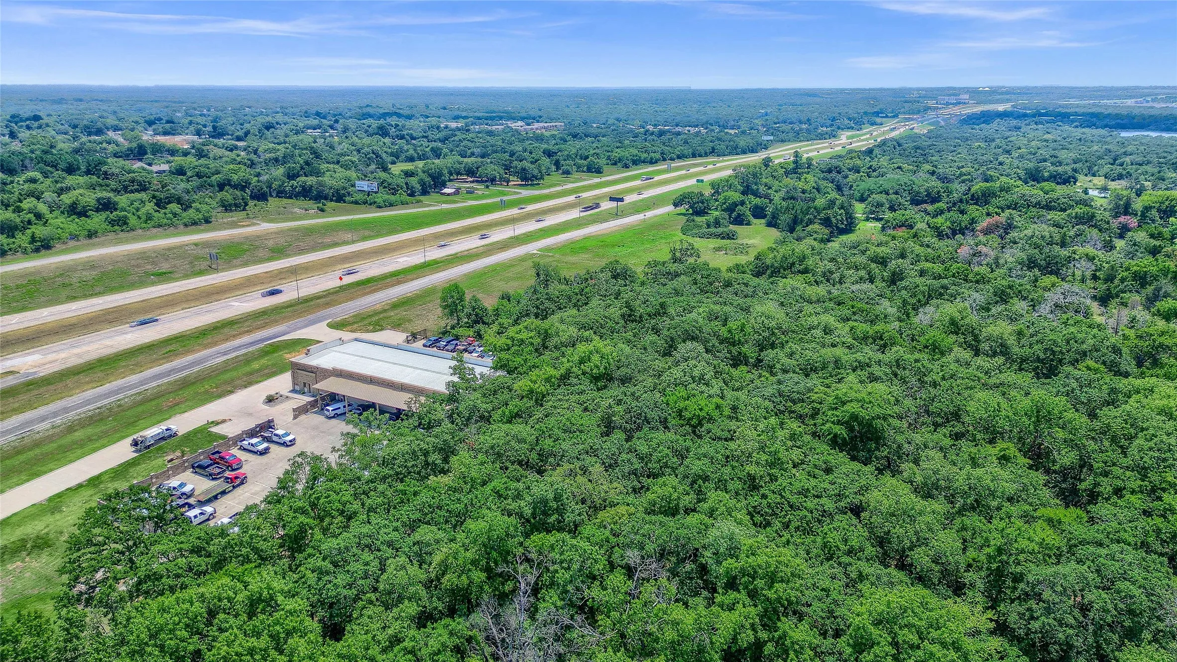 Expansive wooded acreage with a commercial building and direct highway frontage
