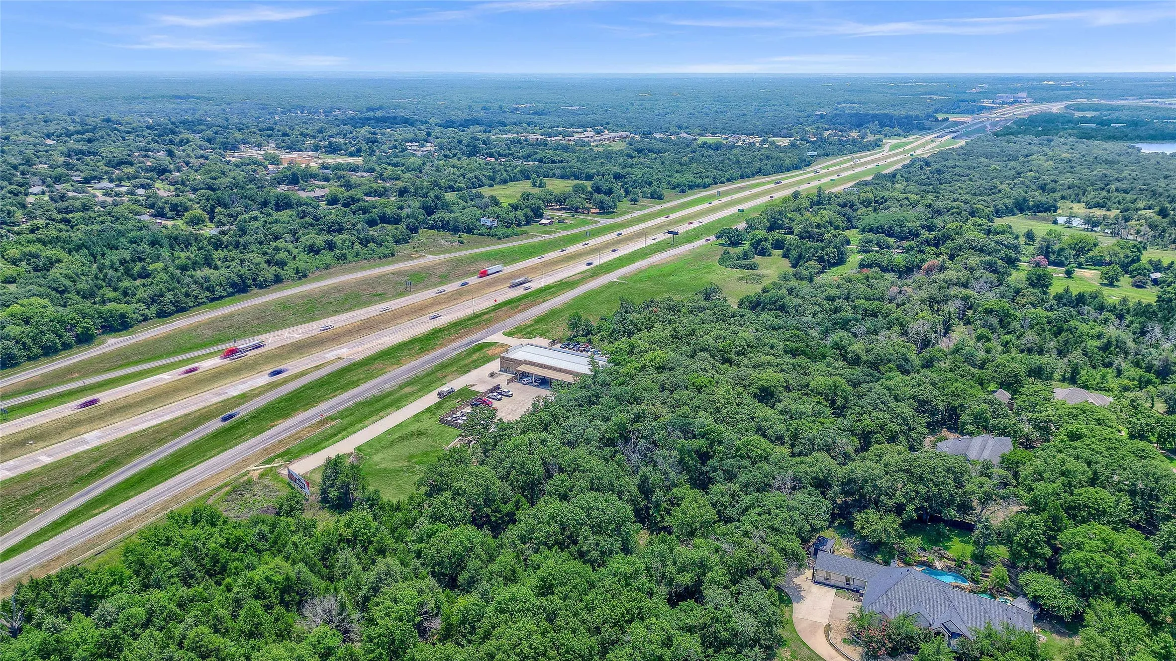 Aerial perspective of a verdant landscape with a prominent highway, demonstrating proximity to transportation corridors
