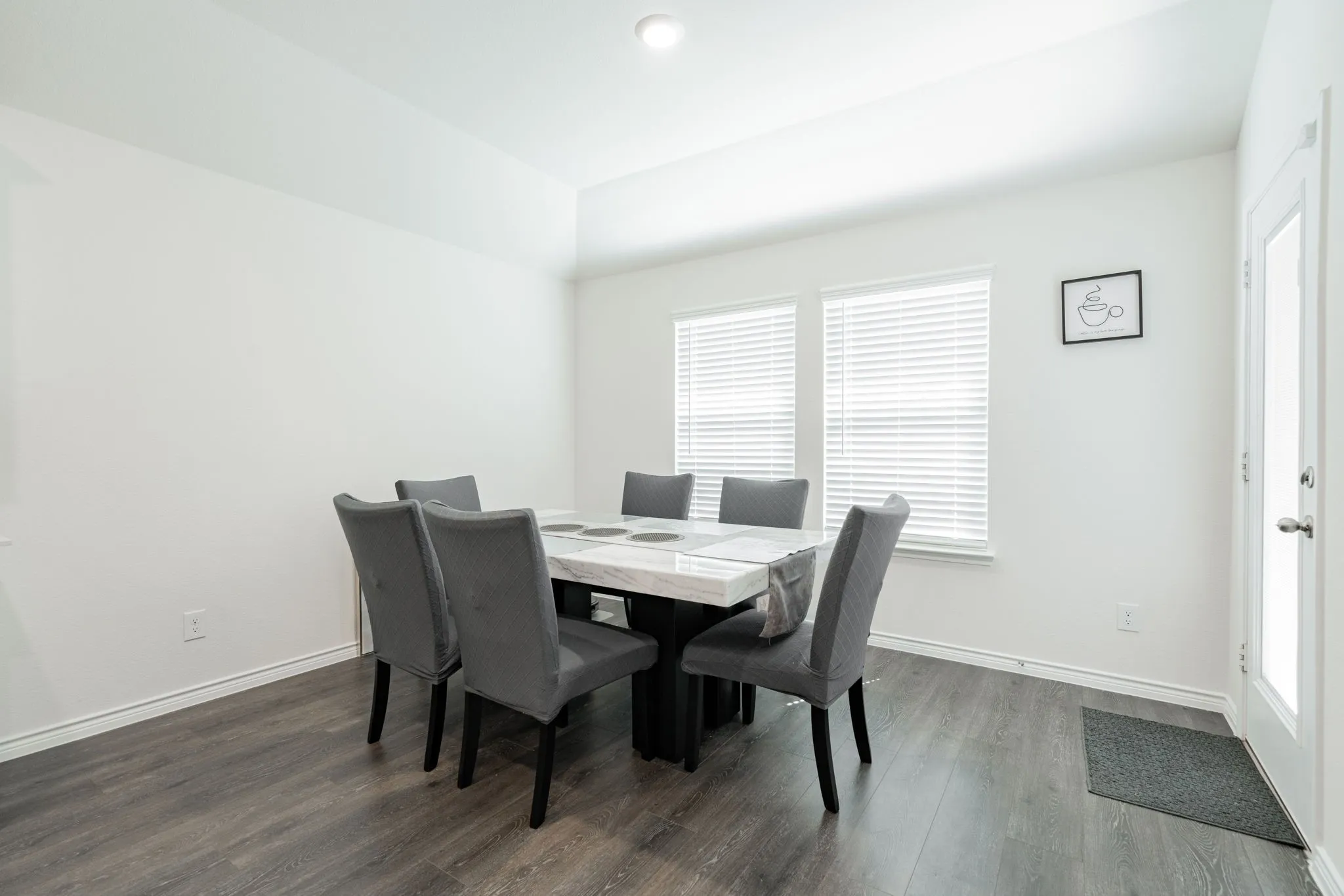 Wood-finish flooring, white trim, recessed lighting, and a white paneled door with glass insert