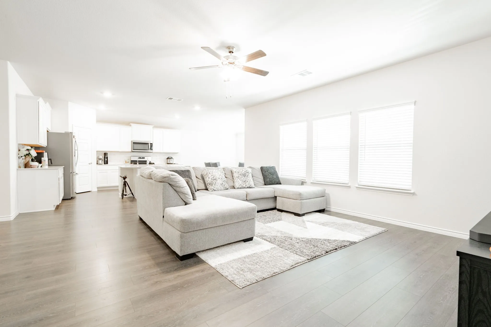 Open-concept living space with wood-finish flooring, recessed lighting, and a ceiling fan