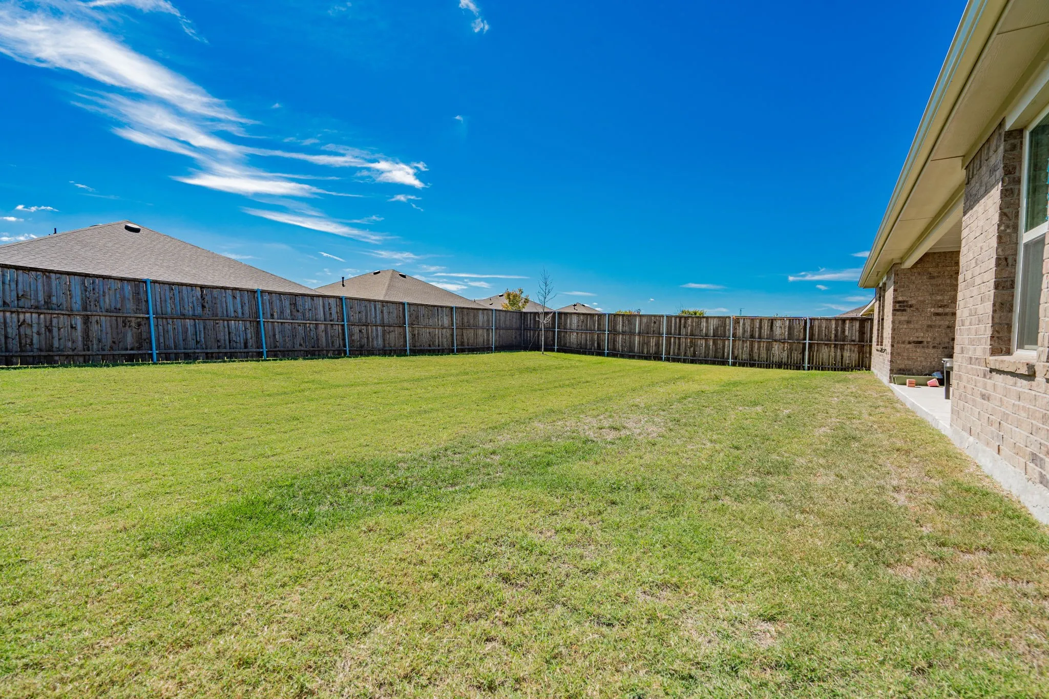 Expansive grass lawn with a full privacy fence