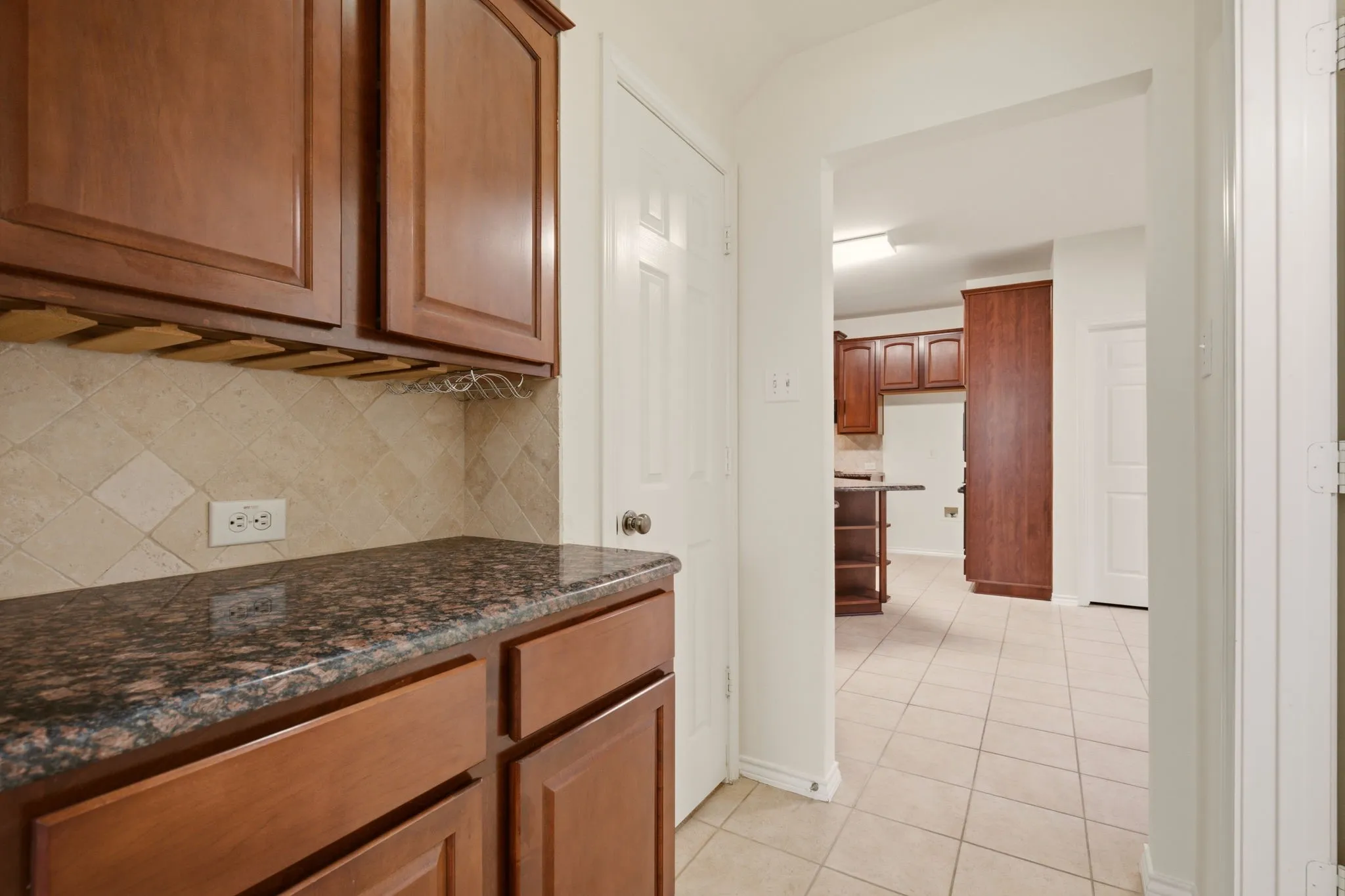 Butler pantry off dining room. Left door is a deep walk-in pantry. A powder bath to the right.