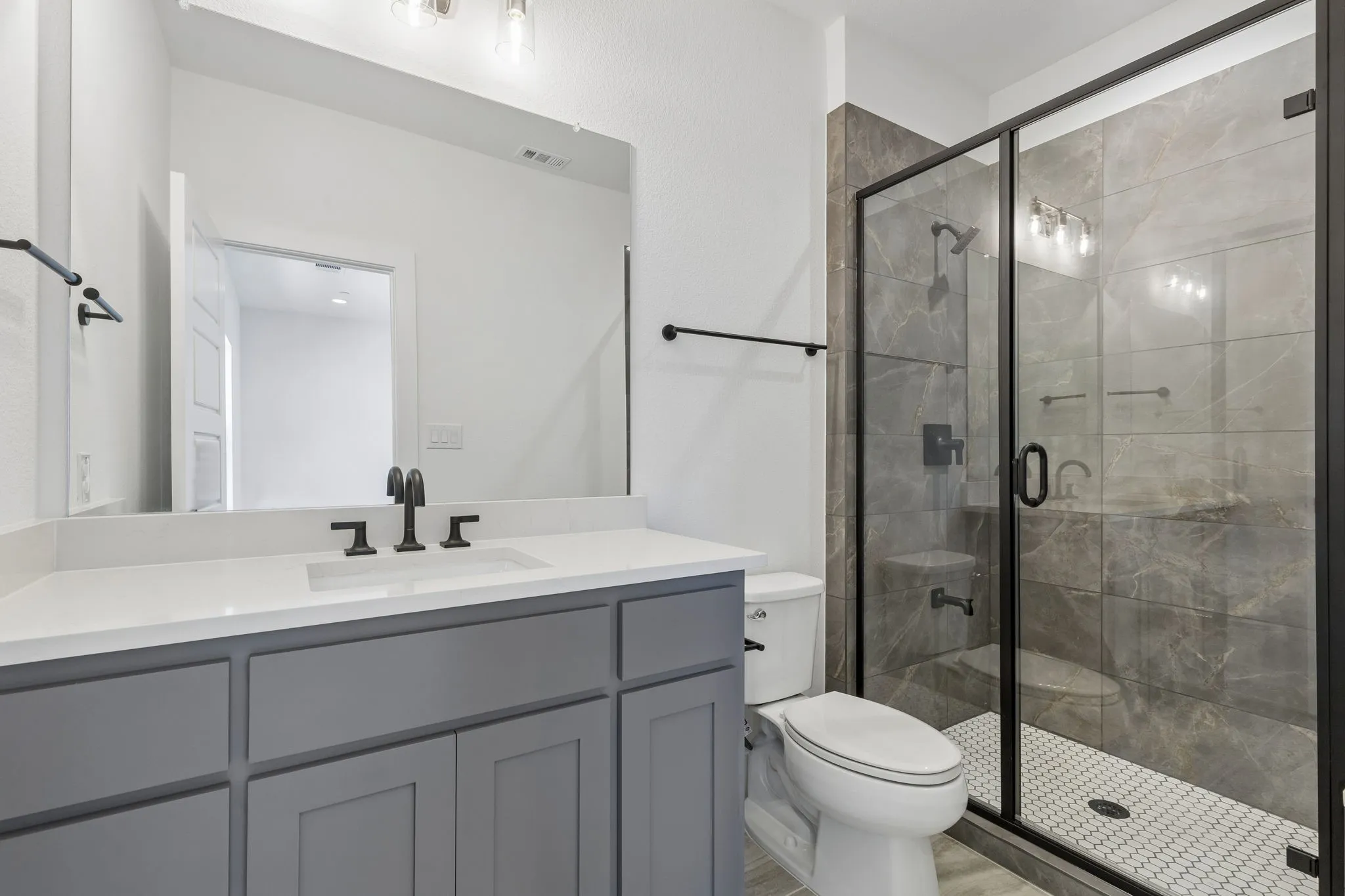 Secondary downstairs bathroom, gray vanity with a white countertop and undermount sink