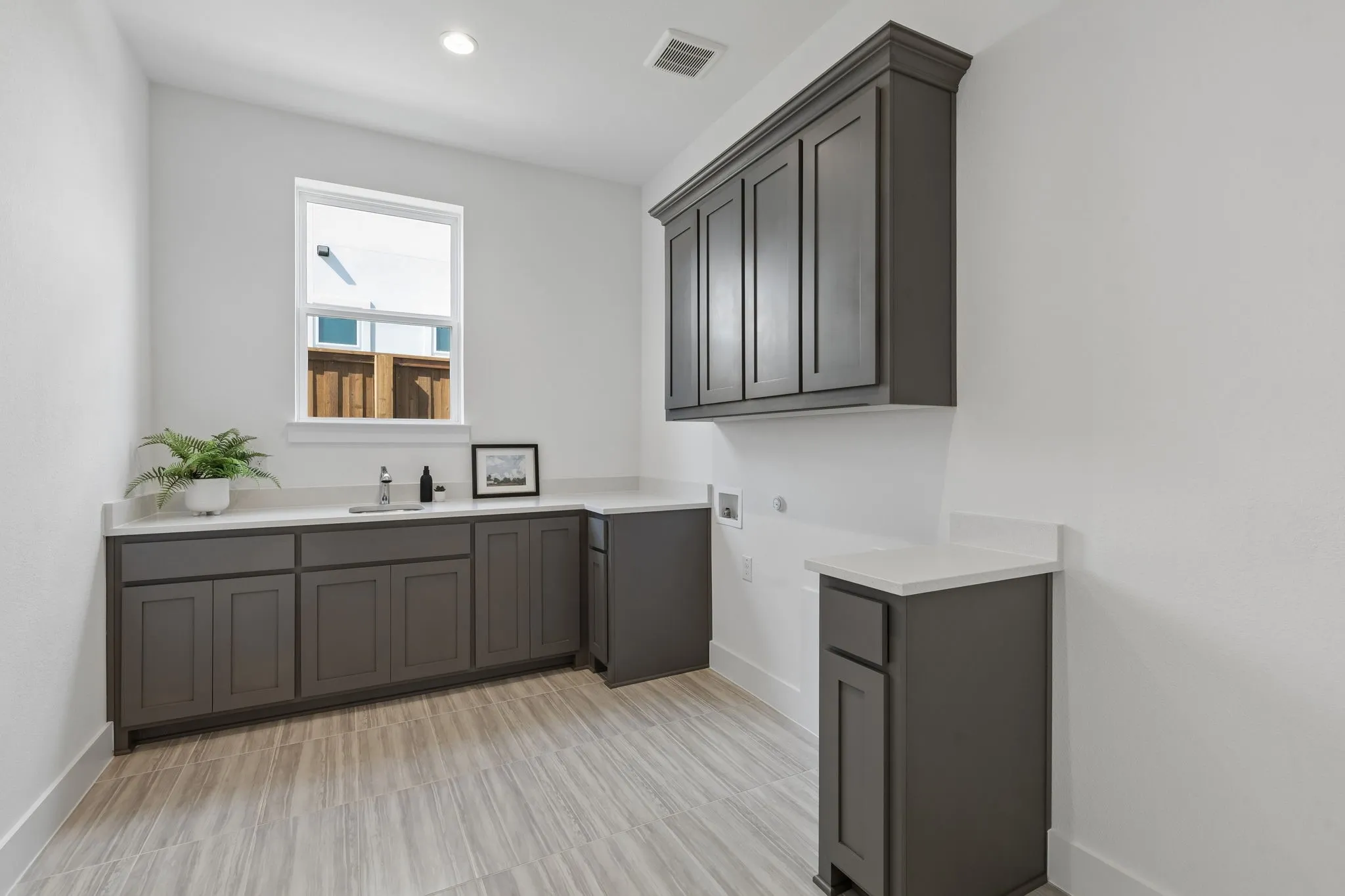 Recessed lighting, wood-finish flooring, white countertops, built-in cabinetry, and a stainless steel sink