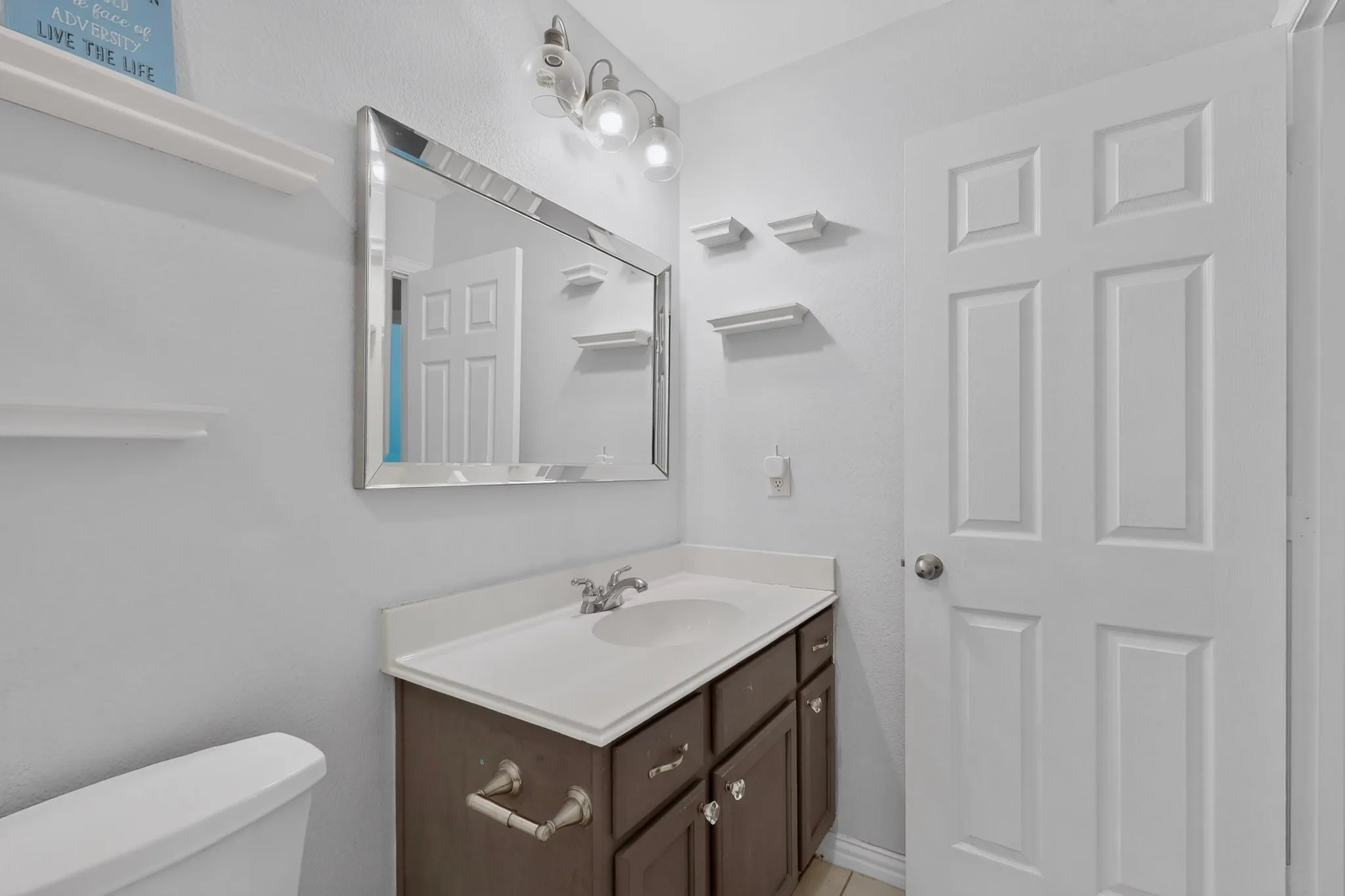 Vanity with integrated sink, rectangular mirror, and three-light fixture